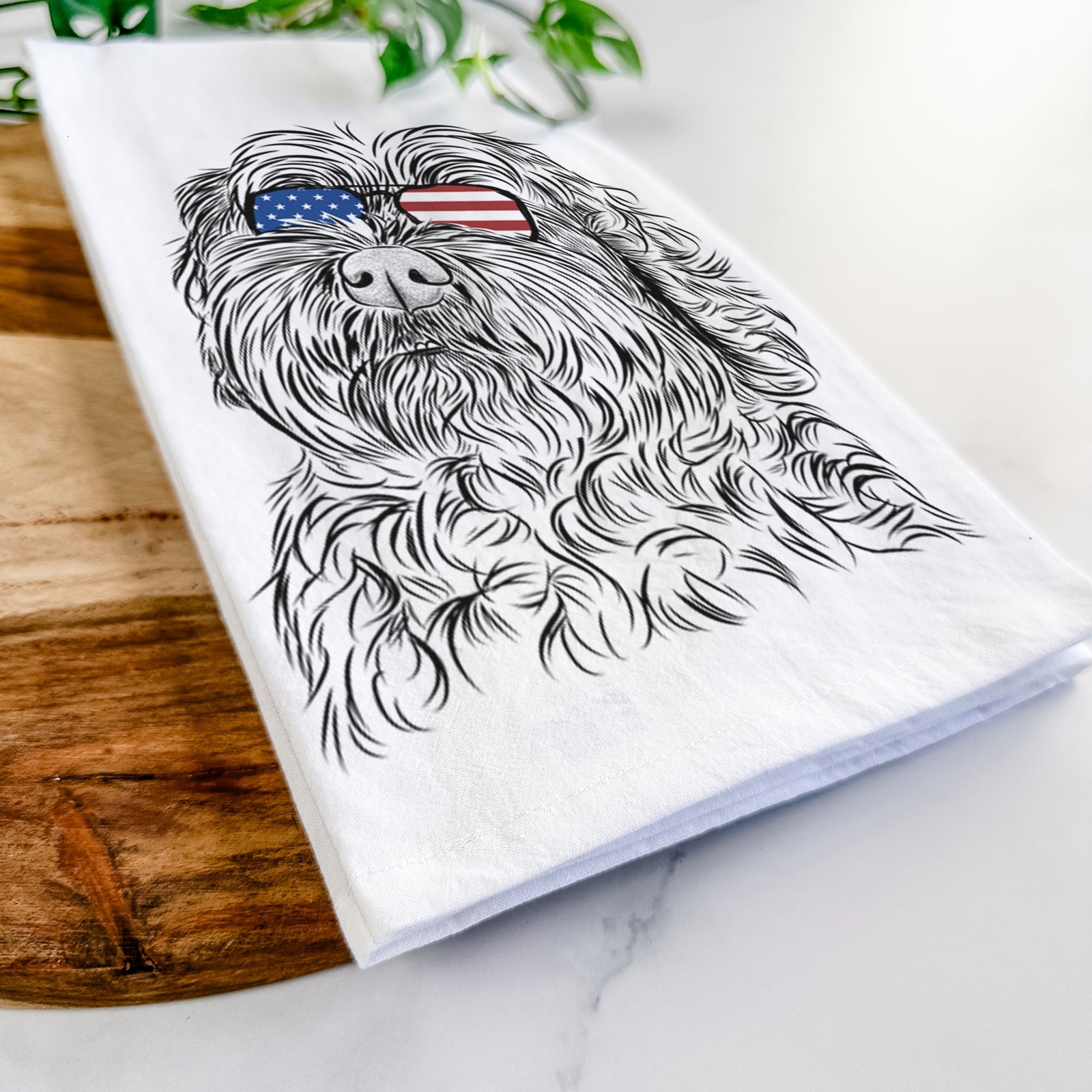 Hand-drawn sketch of Maggie Girl the Cockapoo wearing American flag sunglasses on a tea towel
