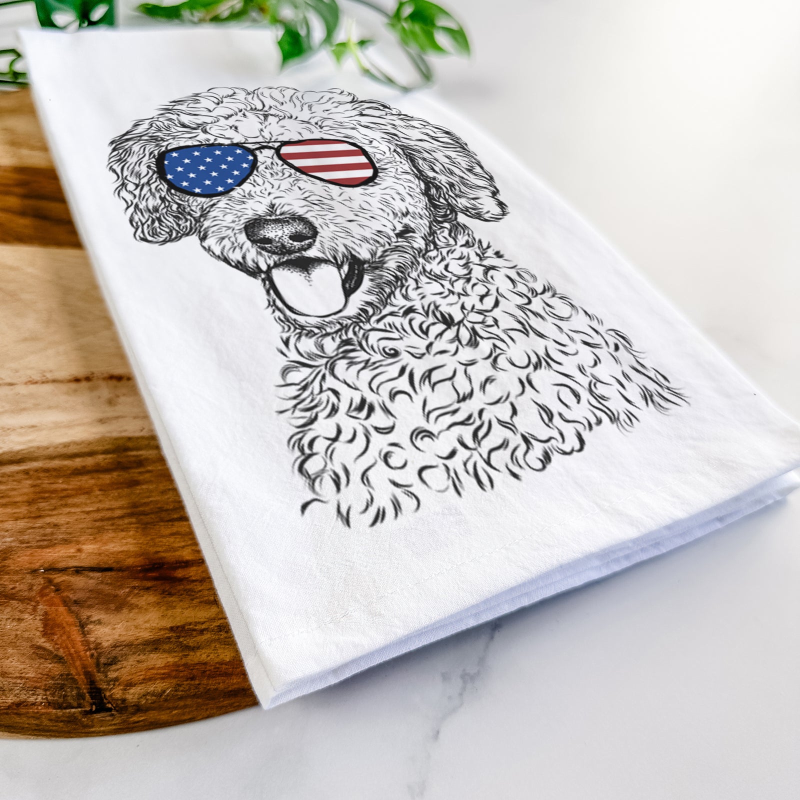 Hand-drawn sketch of Marlow the Goldendoodle wearing American flag sunglasses on a tea towel
