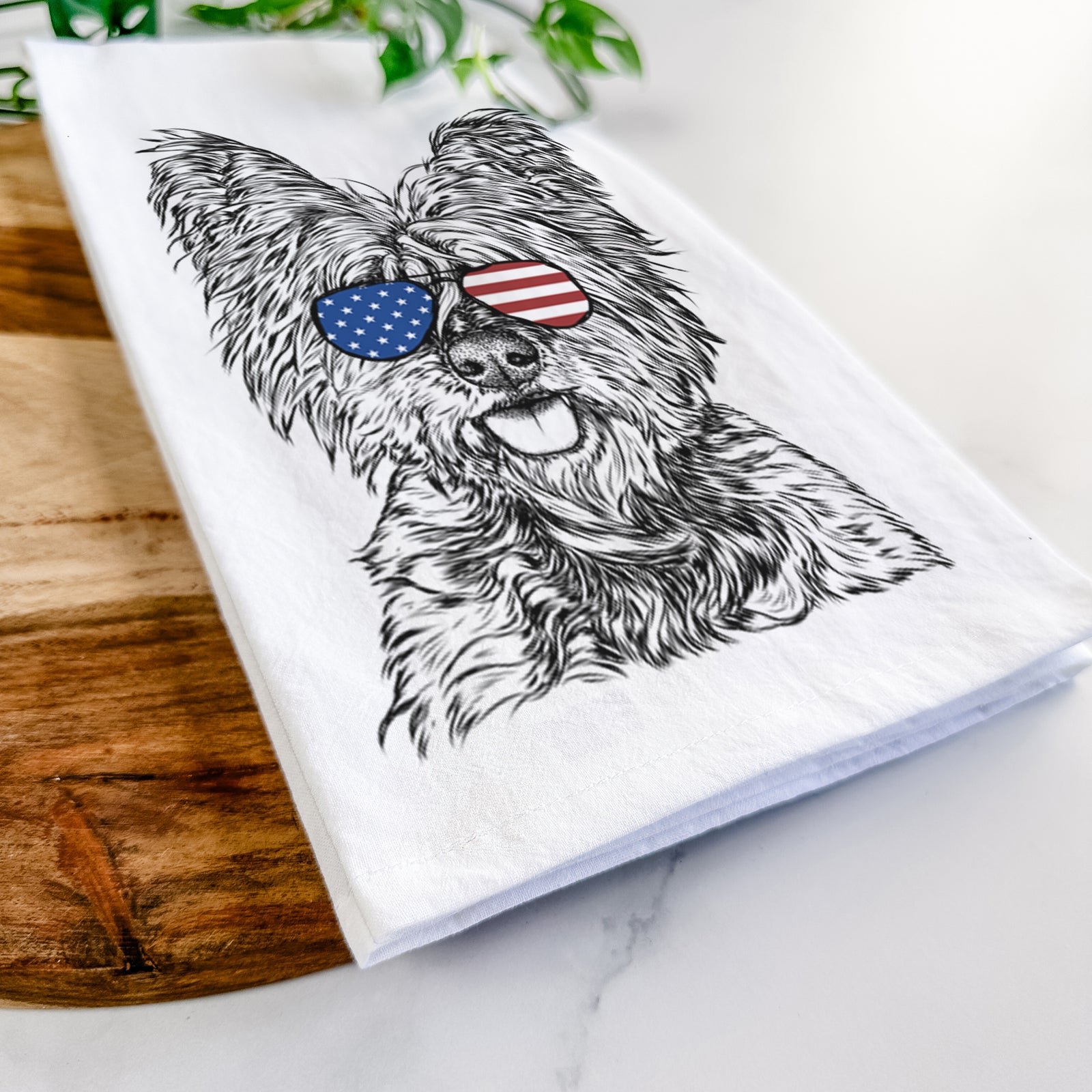 Hand-drawn sketch of McDuff the Cairn Terrier wearing American flag sunglasses on a tea towel