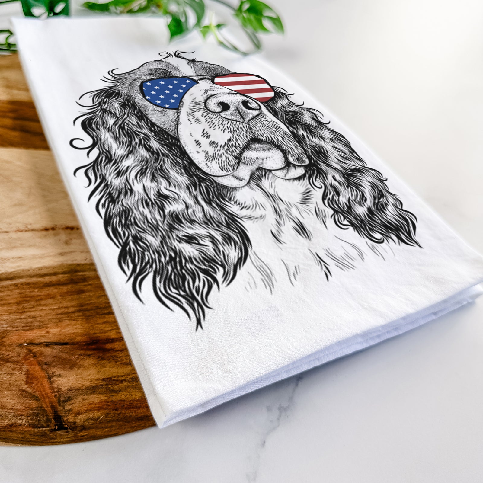 Hand-drawn sketch of Millie Mae the English Springer Spaniel wearing American flag sunglasses on a tea towel