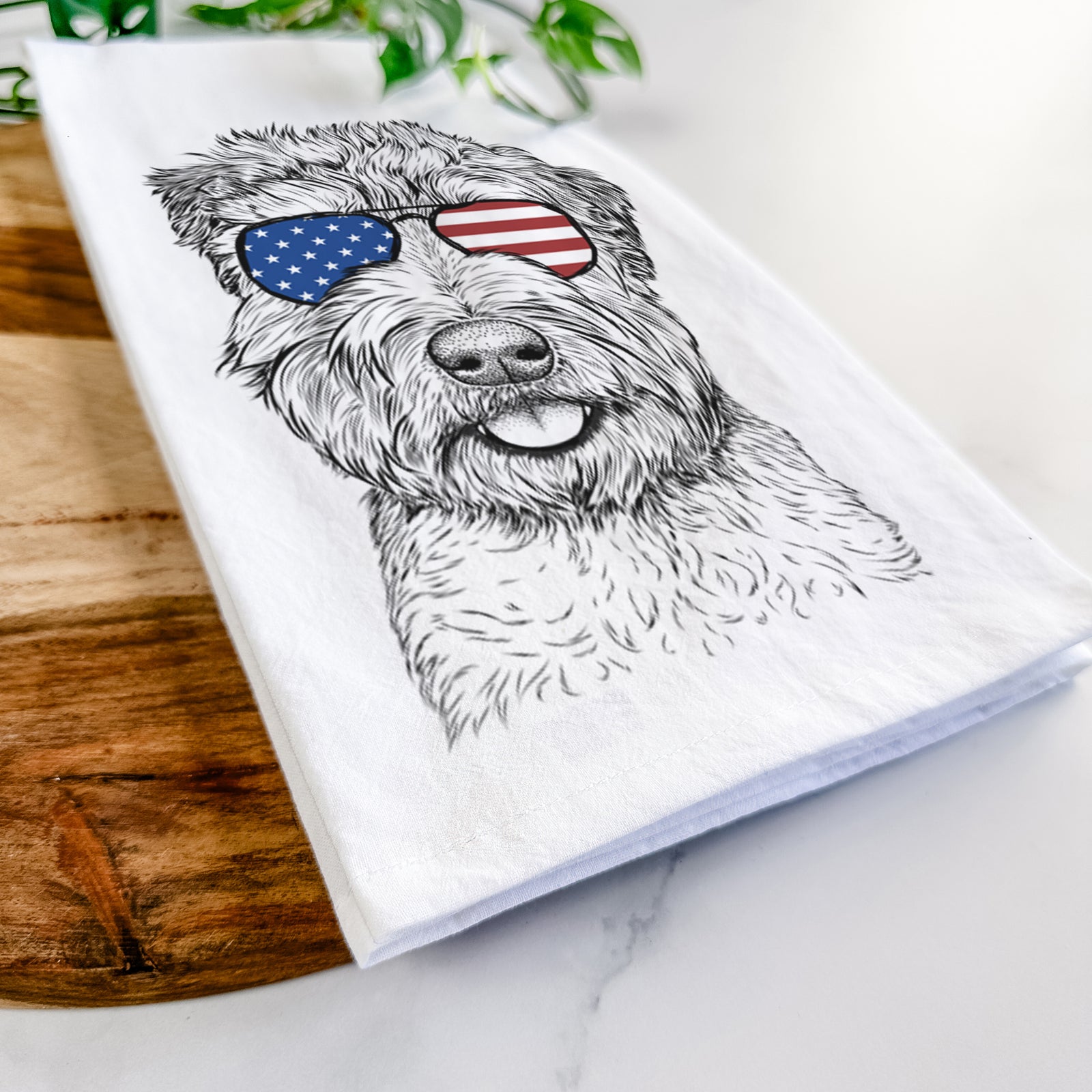 Hand-drawn sketch of Milton the Soft Coated Wheaten Terrier wearing American flag sunglasses on a tea towel