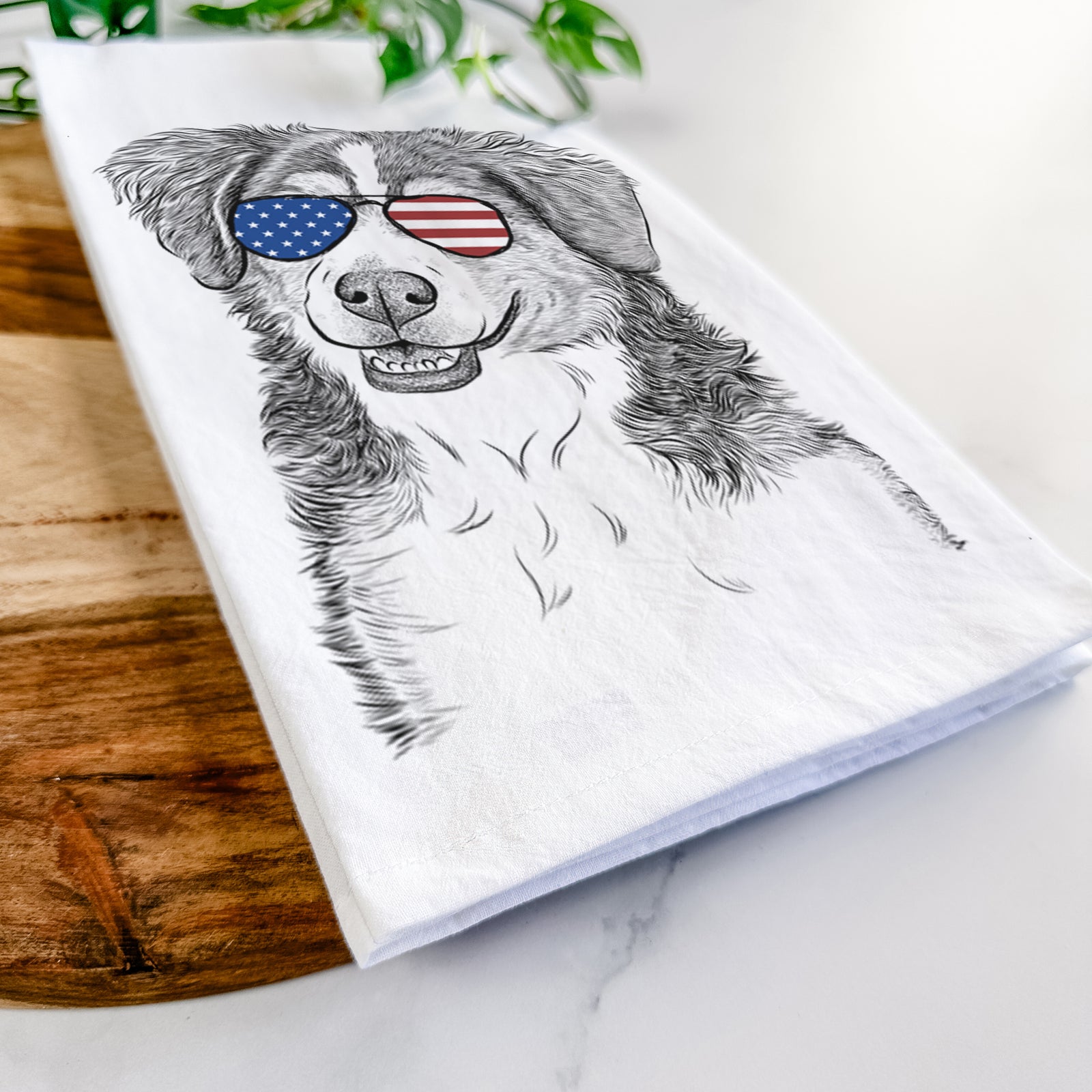 Hand-drawn sketch of Molly the Miniature Bernedoodle wearing American flag sunglasses on a tea towel