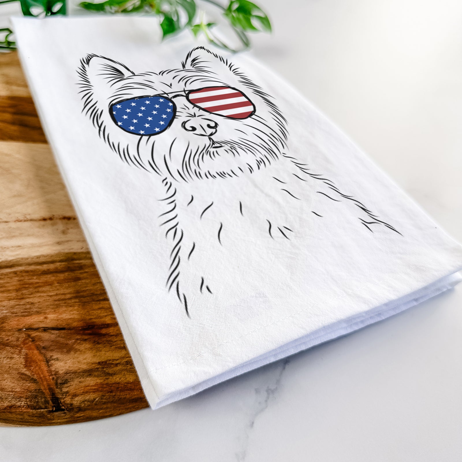 Hand-drawn sketch of Murphy the West Highland Terrier wearing American flag sunglasses on a tea towel