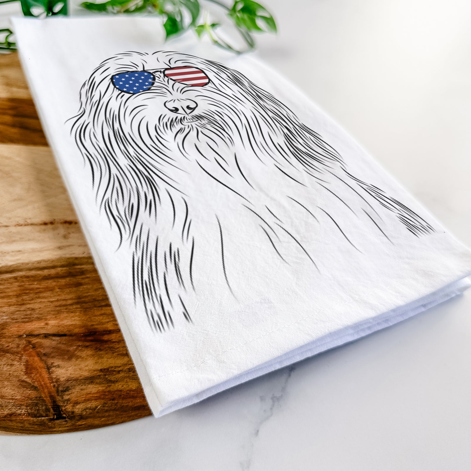 Hand-drawn sketch of Murray the Bearded Collie wearing American flag sunglasses on a tea towel