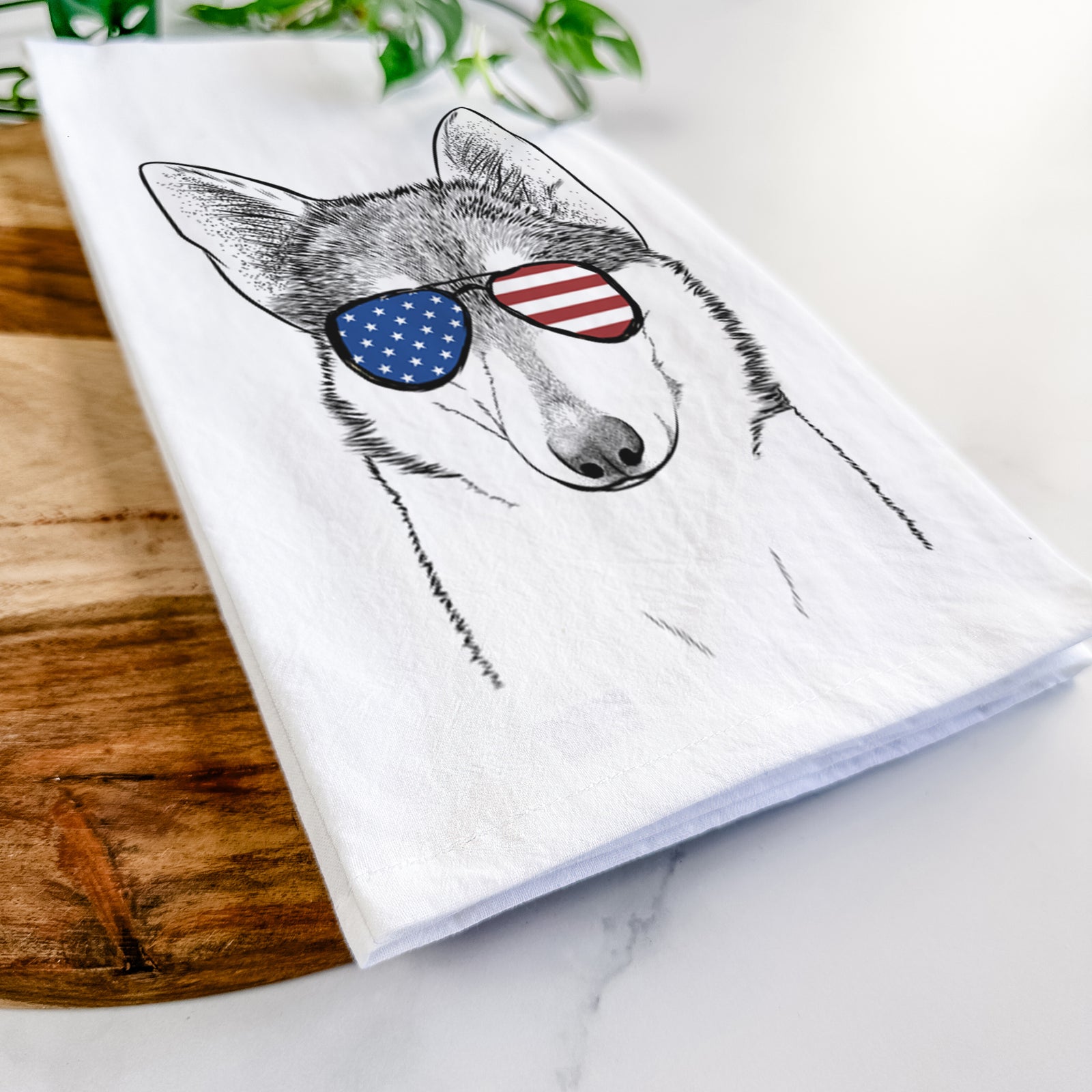 Hand-drawn sketch of Nami the Alaskan Klee Kai wearing American flag sunglasses on a tea towel