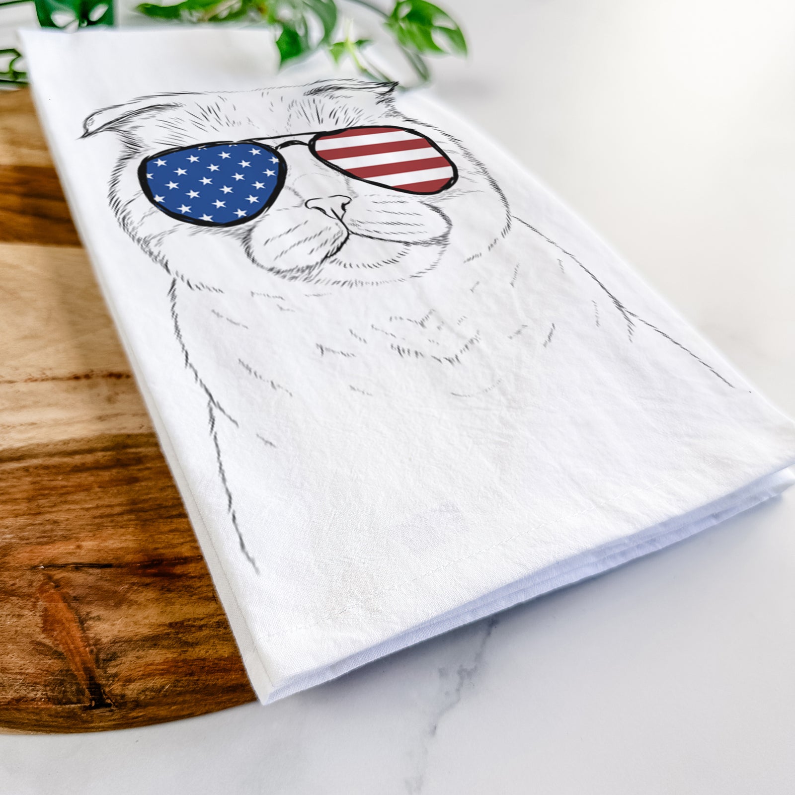 Hand-drawn sketch of Neko the Scottish Fold Cat wearing American flag sunglasses on a tea towel