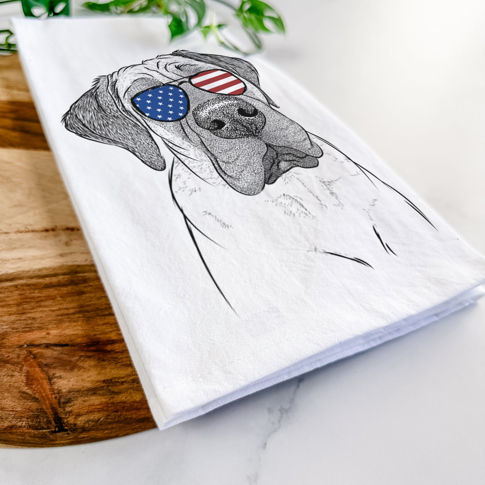 Hand-drawn sketch of Nutterbutter the English Mastiff wearing American flag sunglasses on a tea towel