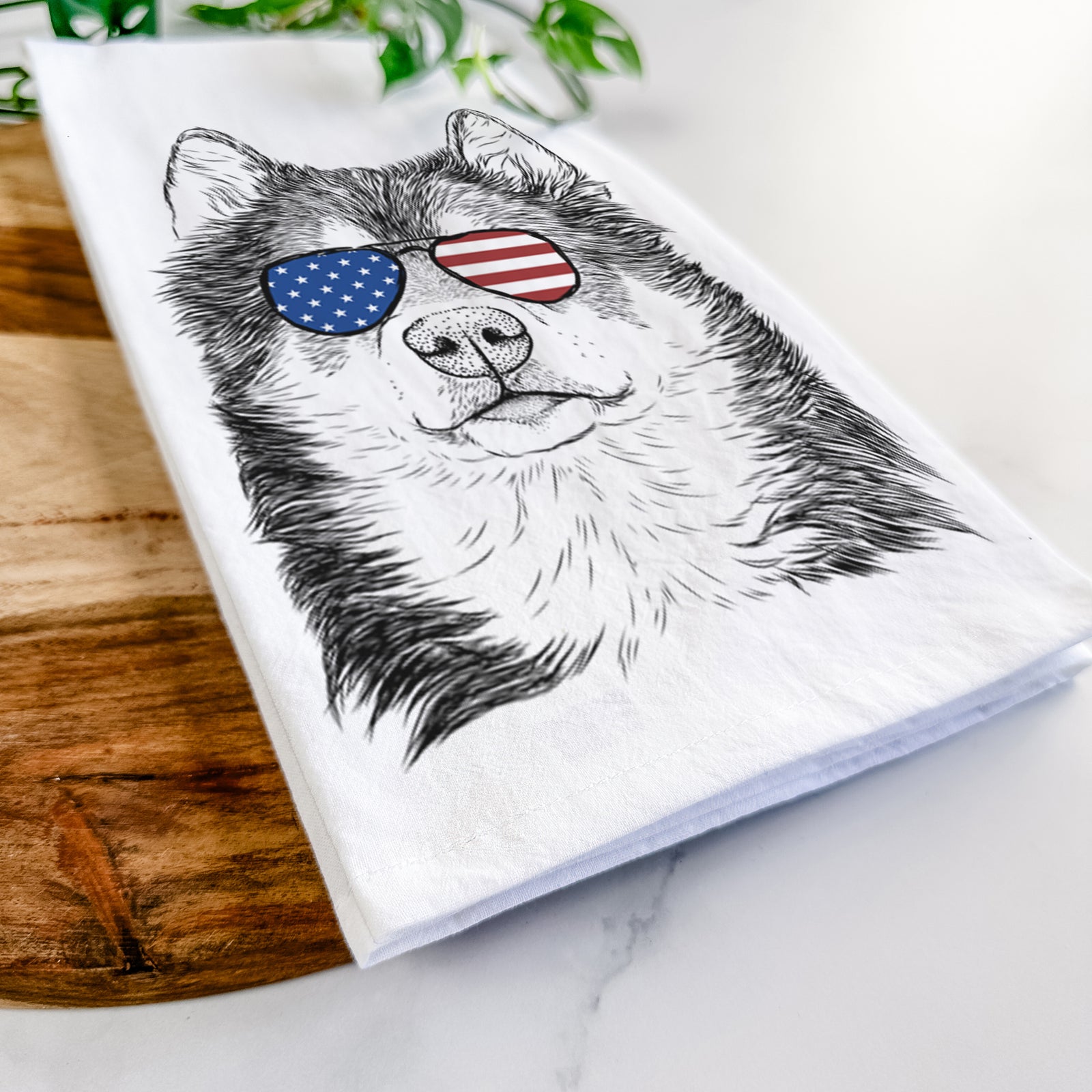 Hand-drawn sketch of Oskar the Canadian Eskimo Dog wearing American flag sunglasses on a tea towel