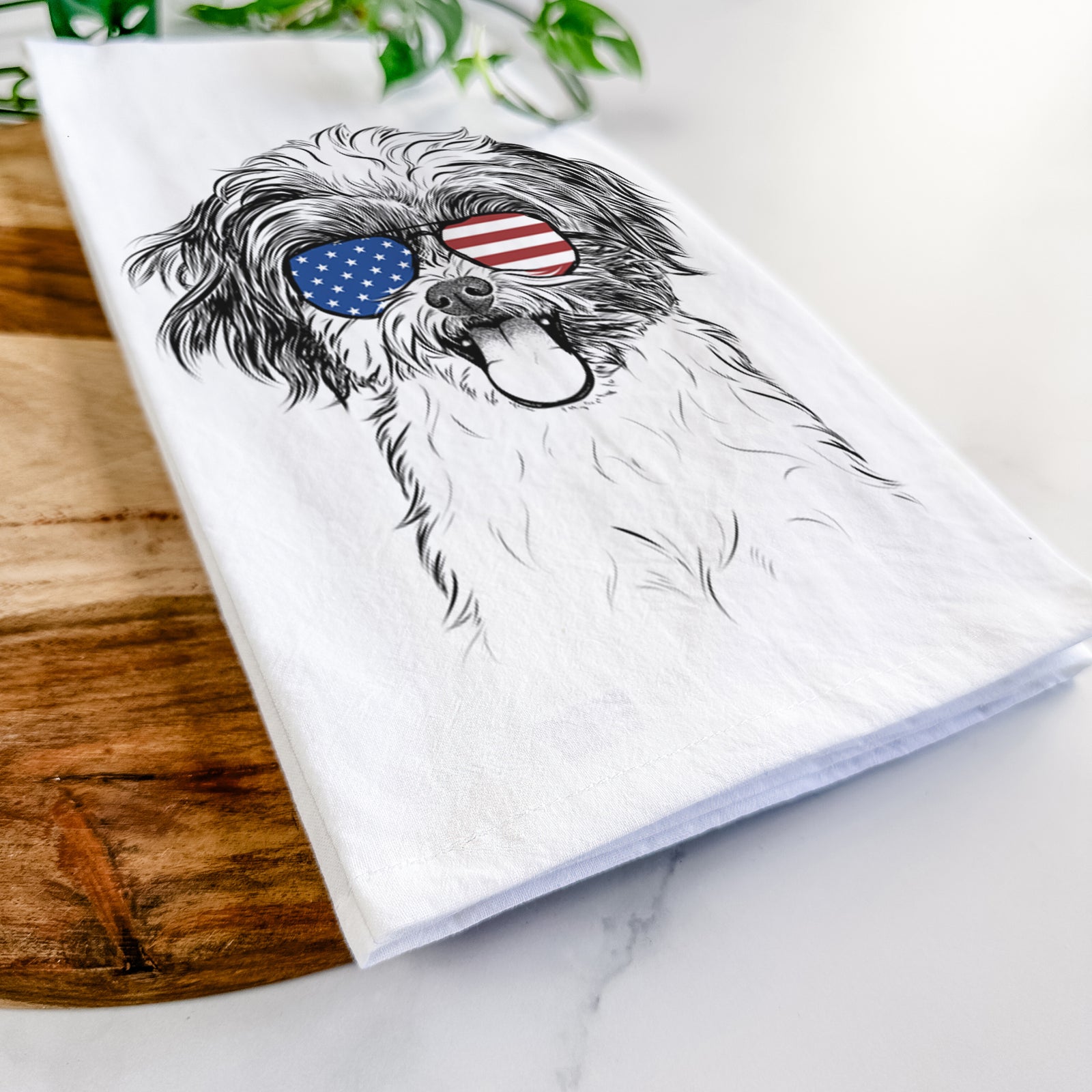 Hand-drawn sketch of Pepper the Shihpoo wearing American flag sunglasses on a tea towel