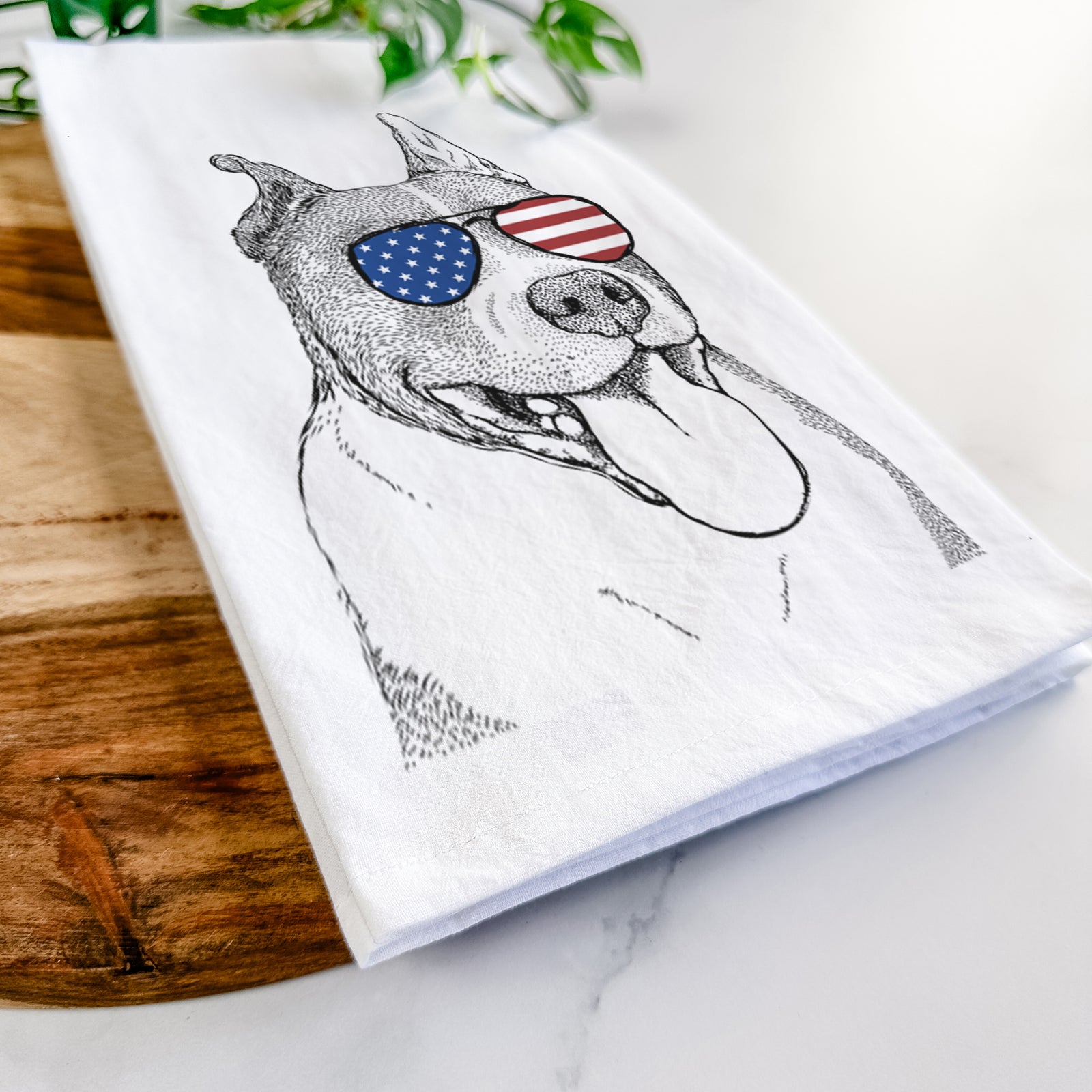 Hand-drawn sketch of Piggy the American Staffordshire Terrier wearing American flag sunglasses on a tea towel
