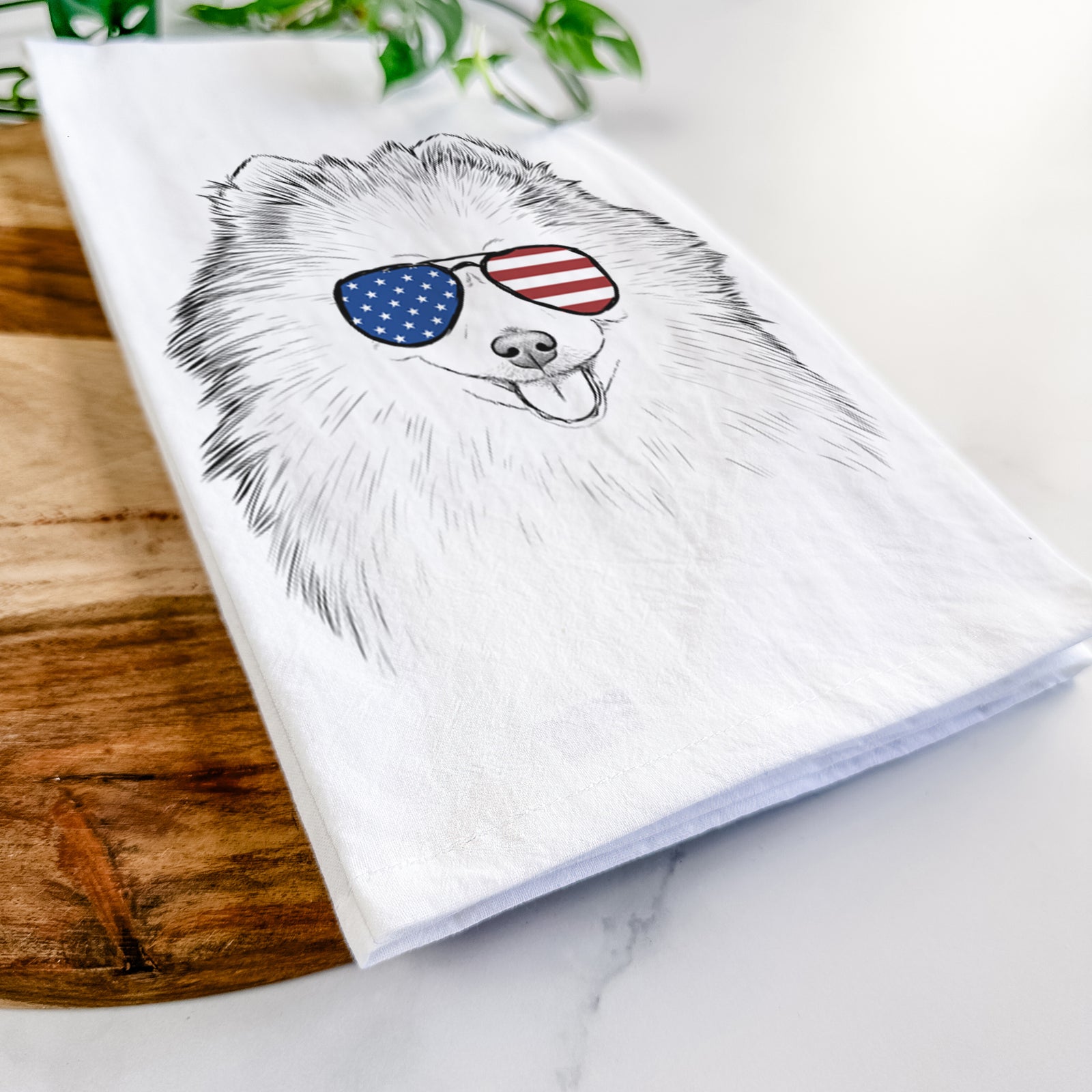 Hand-drawn sketch of Piper Jo the Pomeranian wearing American flag sunglasses on a tea towel