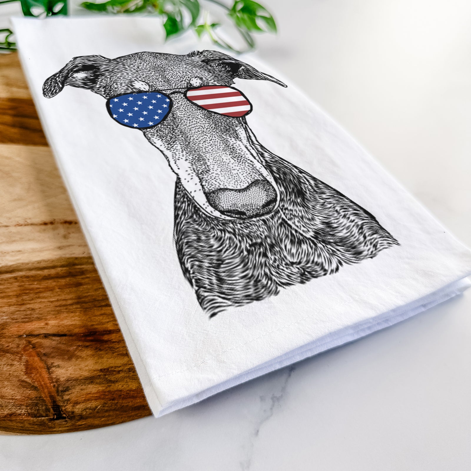 Hand-drawn sketch of Princess Fiona the Doberman Pinscher wearing American flag sunglasses on a tea towel