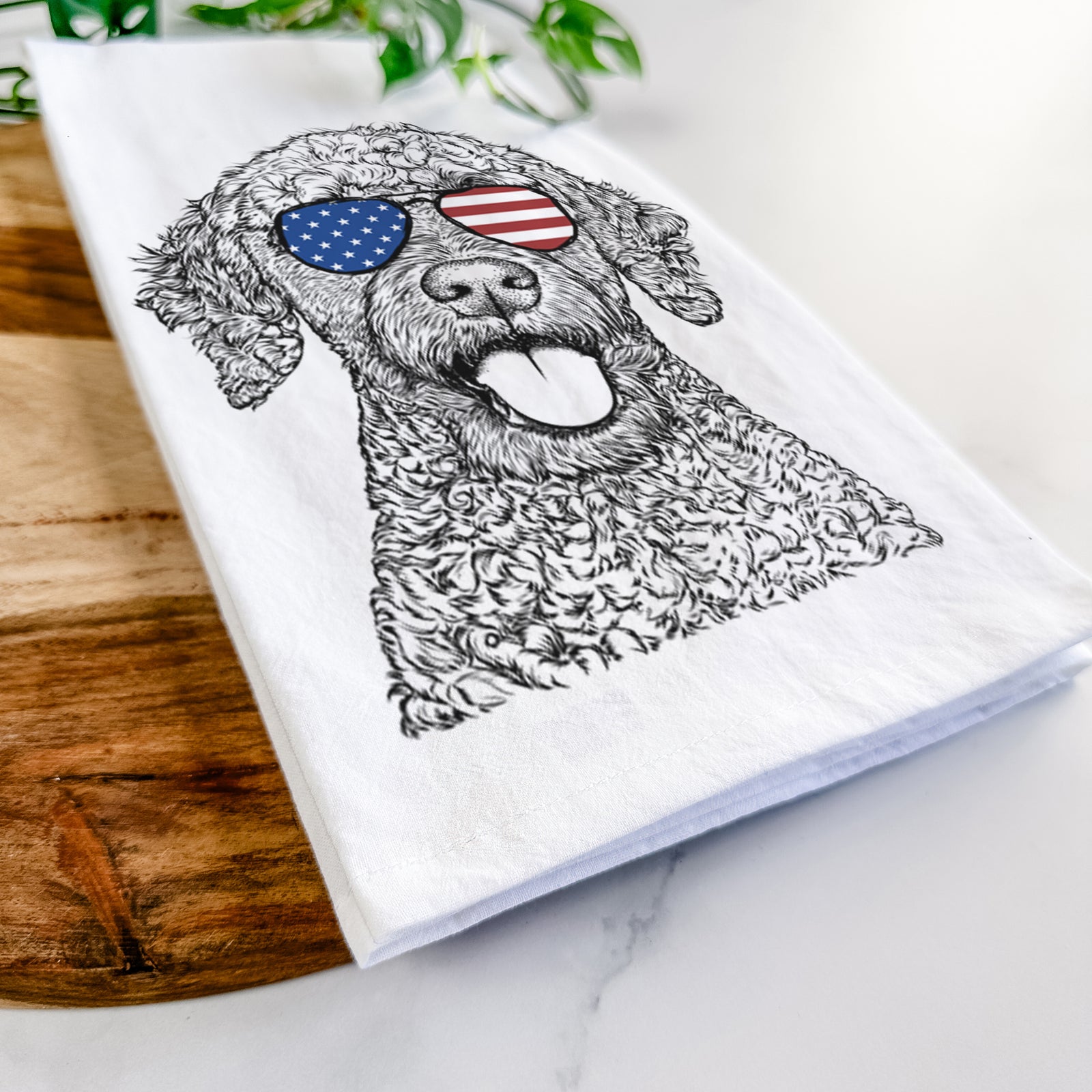 Hand-drawn sketch of Reina the Spanish Water Dog wearing American flag sunglasses on a tea towel