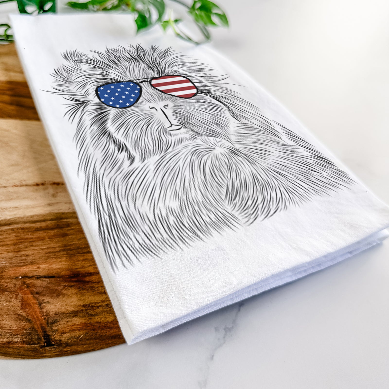 Hand-drawn sketch of Rhino the Guinea Pig wearing American flag sunglasses on a tea towel