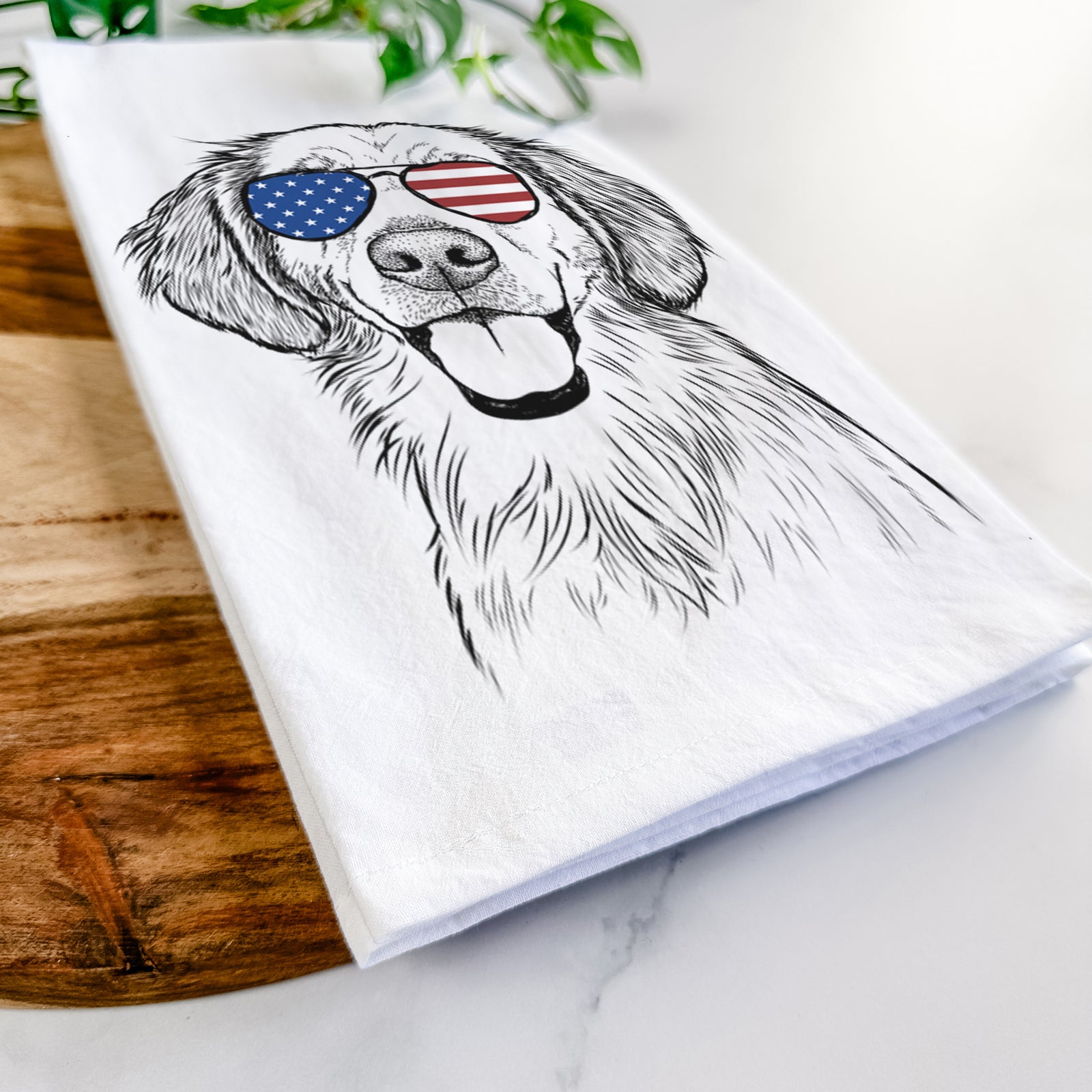 Hand-drawn sketch of Riley the Golden Retriever wearing American flag sunglasses on a tea towel