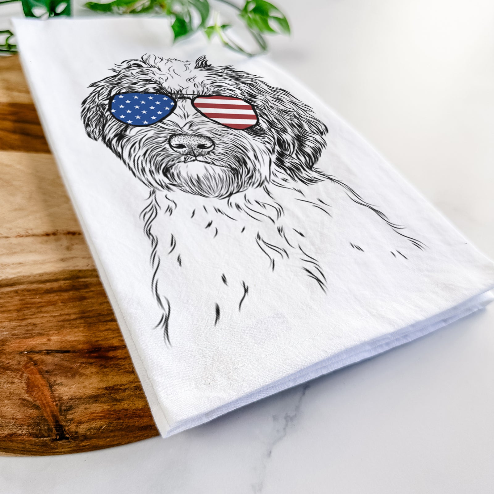 Hand-drawn sketch of Rooney the Aussiedoodle wearing American flag sunglasses on a tea towel