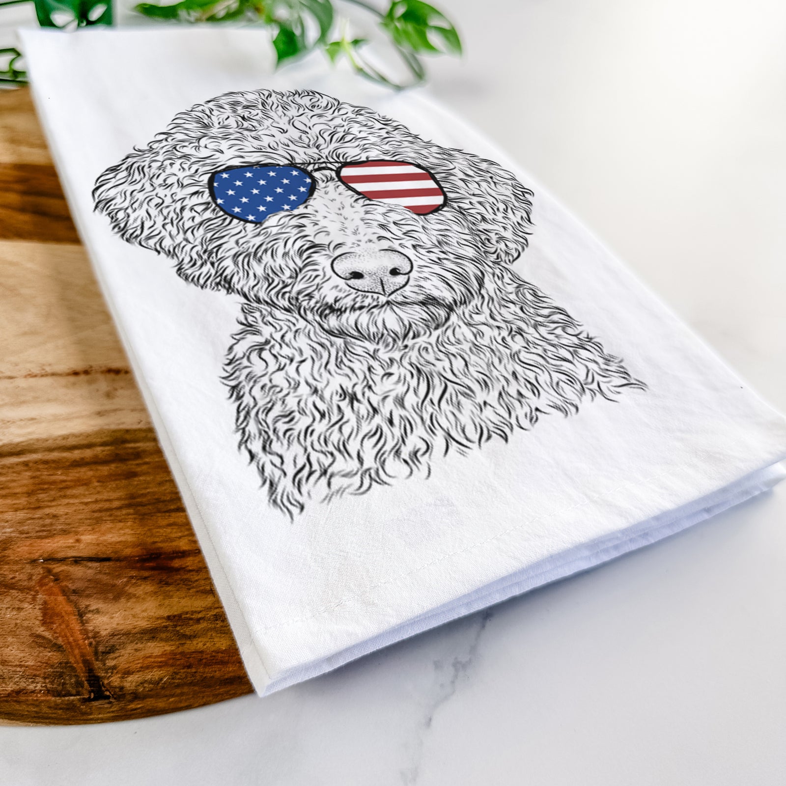 Hand-drawn sketch of Ross the Lagotto Romagnolo wearing American flag sunglasses on a tea towel
