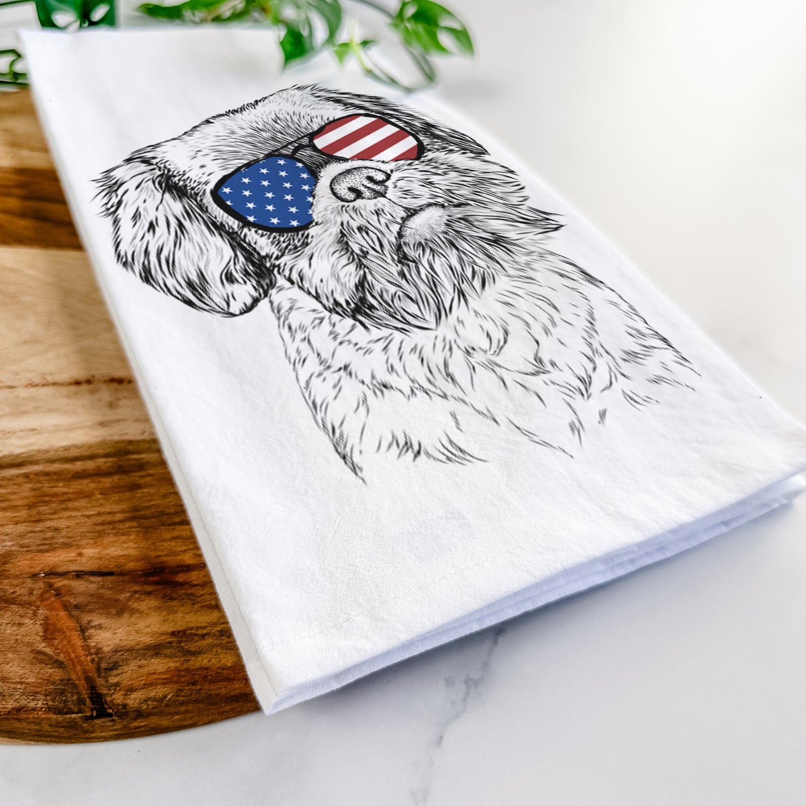 Hand-drawn sketch of Rufus the Shiffon wearing American flag sunglasses on a tea towel