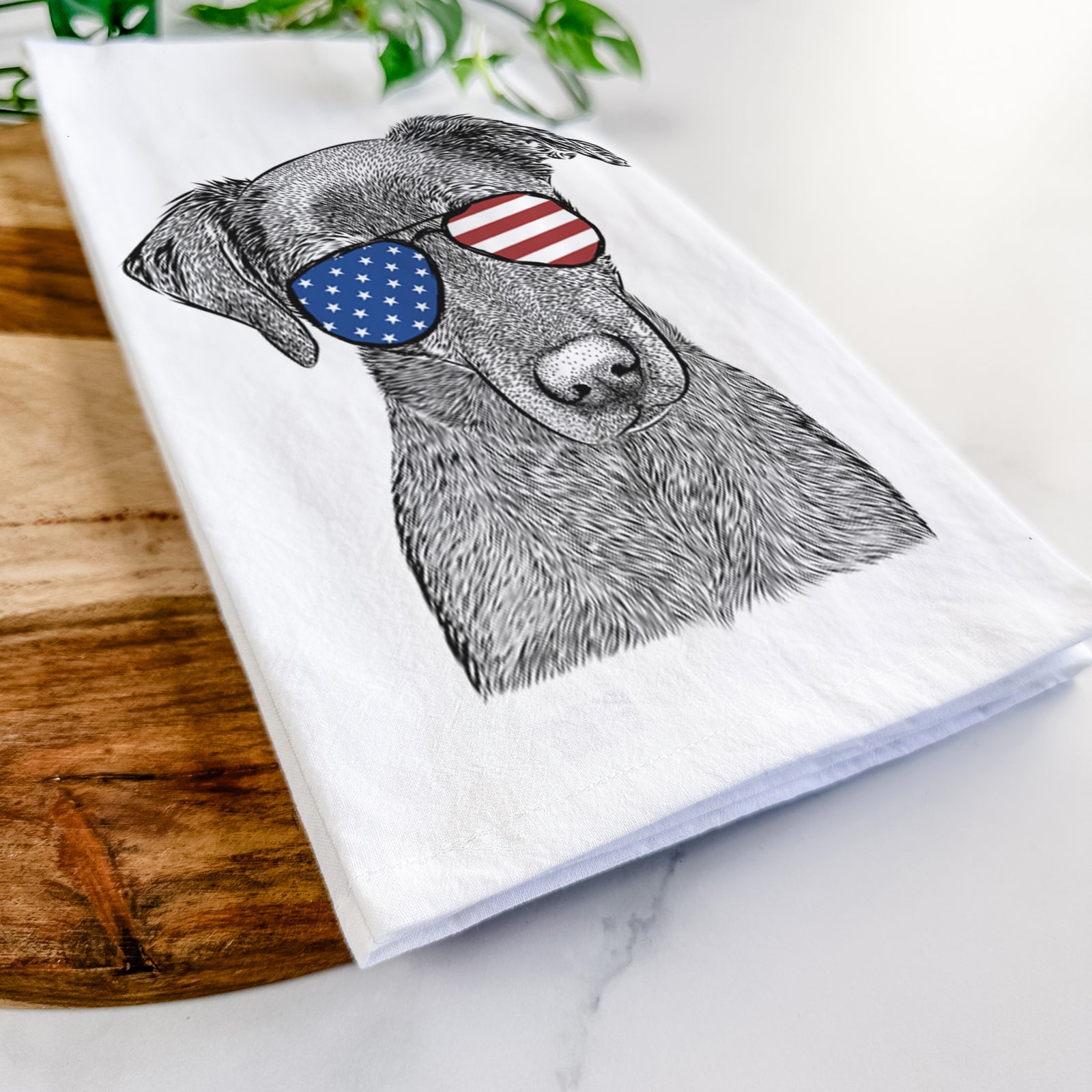 Hand-drawn sketch of Sadie the Whipador wearing American flag sunglasses on a tea towel