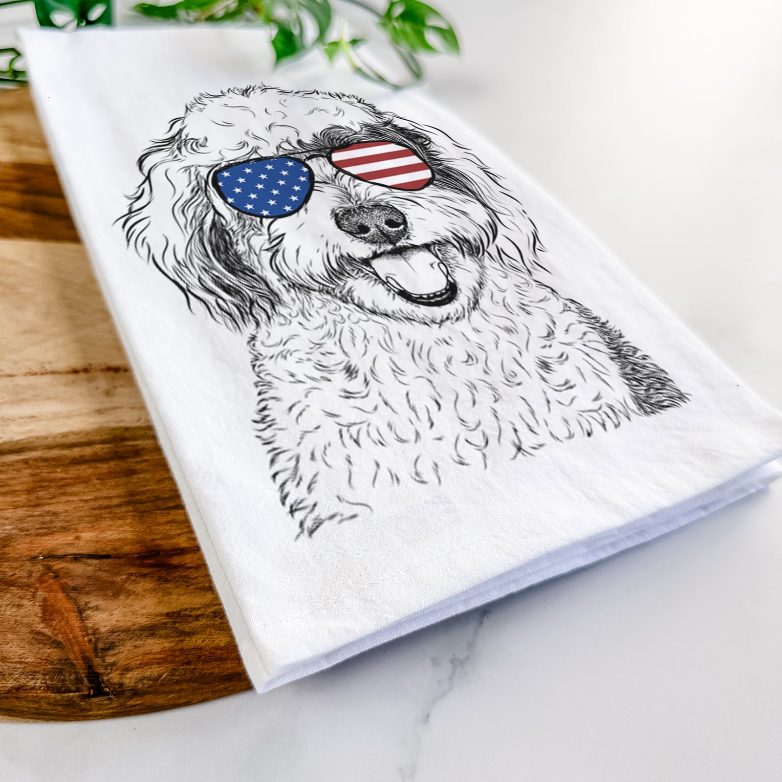 Hand-drawn sketch of Sherlock the Sheepadoodle wearing American flag sunglasses on a tea towel