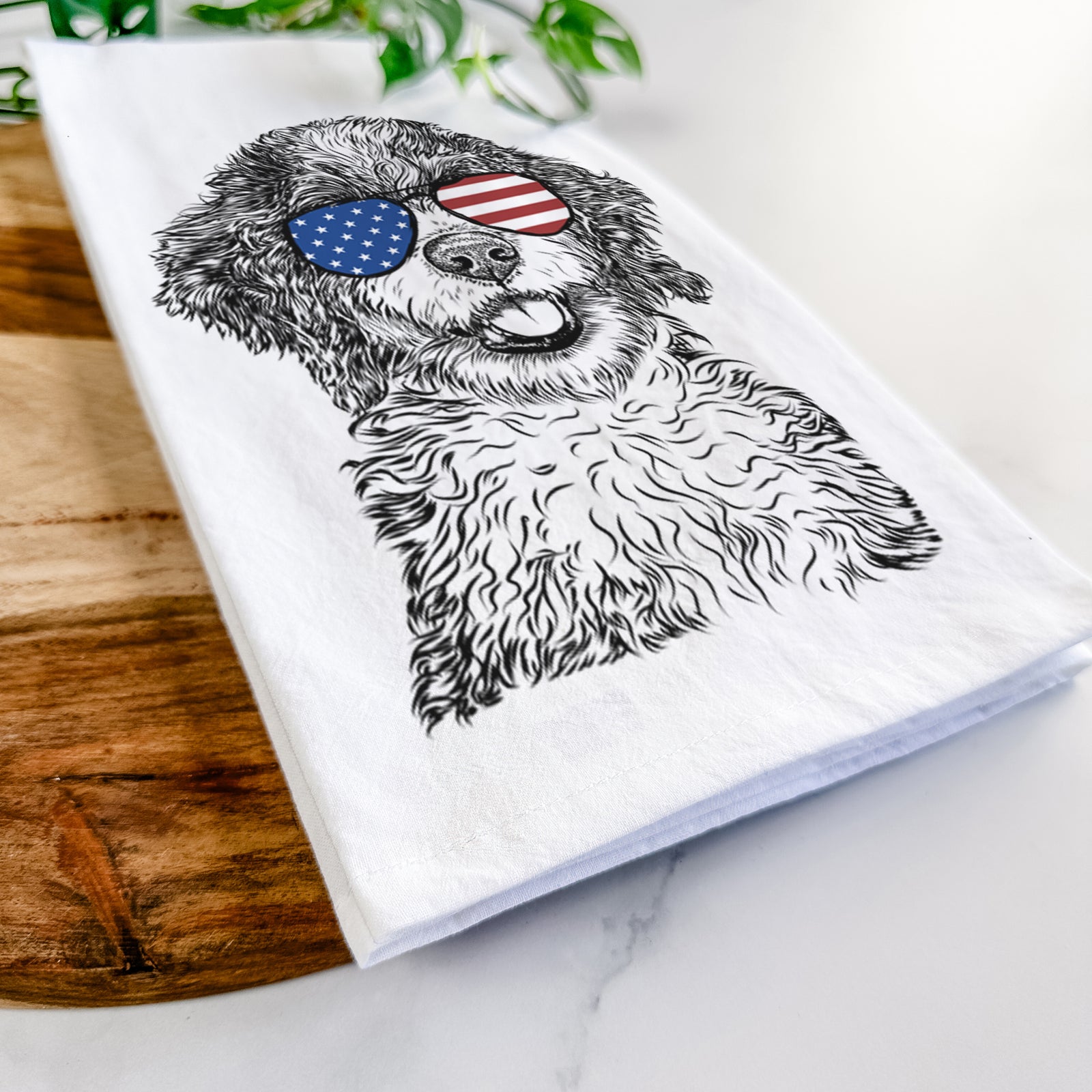 Hand-drawn sketch of Smoky the Bernedoodle Puppy wearing American flag sunglasses on a tea towel
