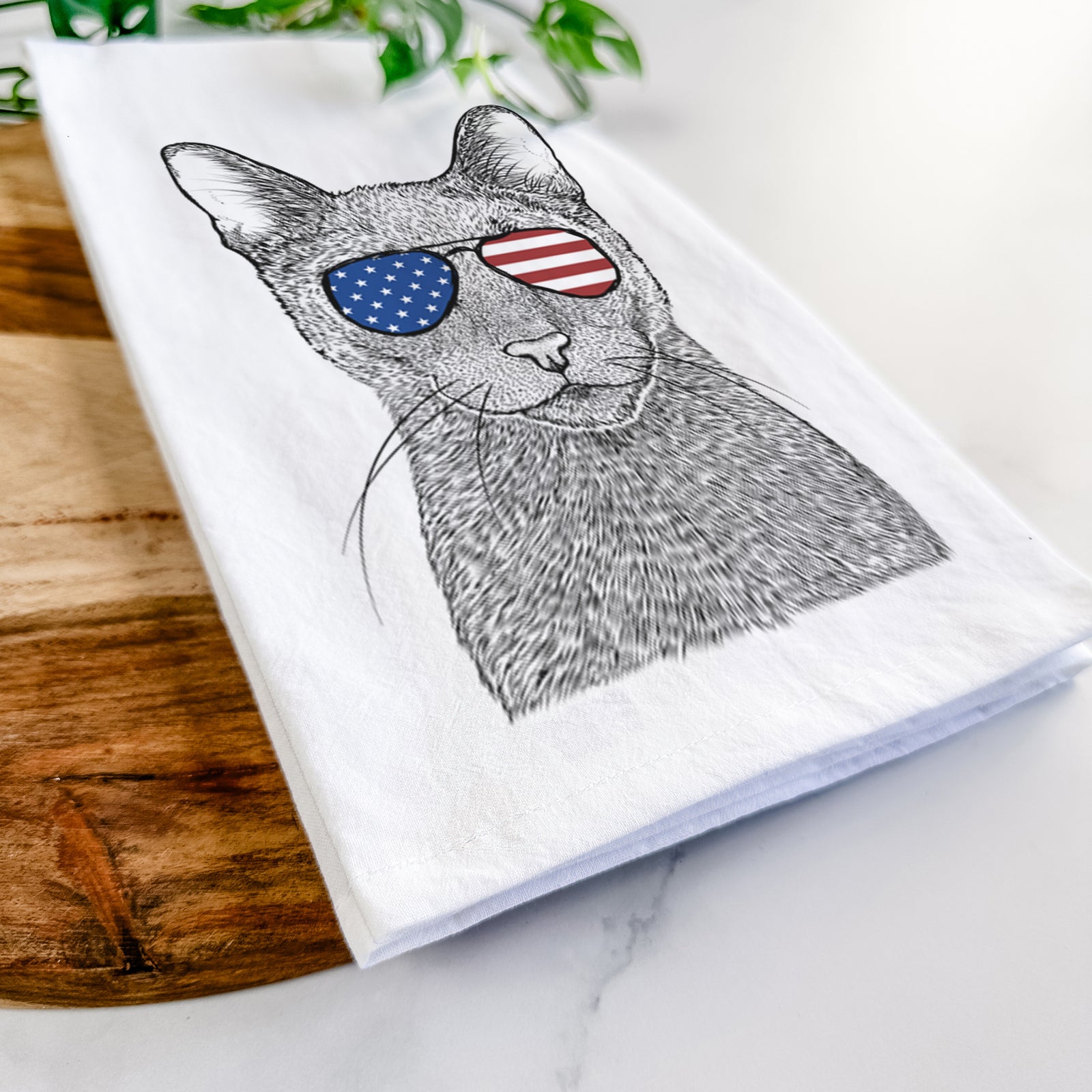 Hand-drawn sketch of Stanley the Russian Blue Cat wearing American flag sunglasses on a tea towel