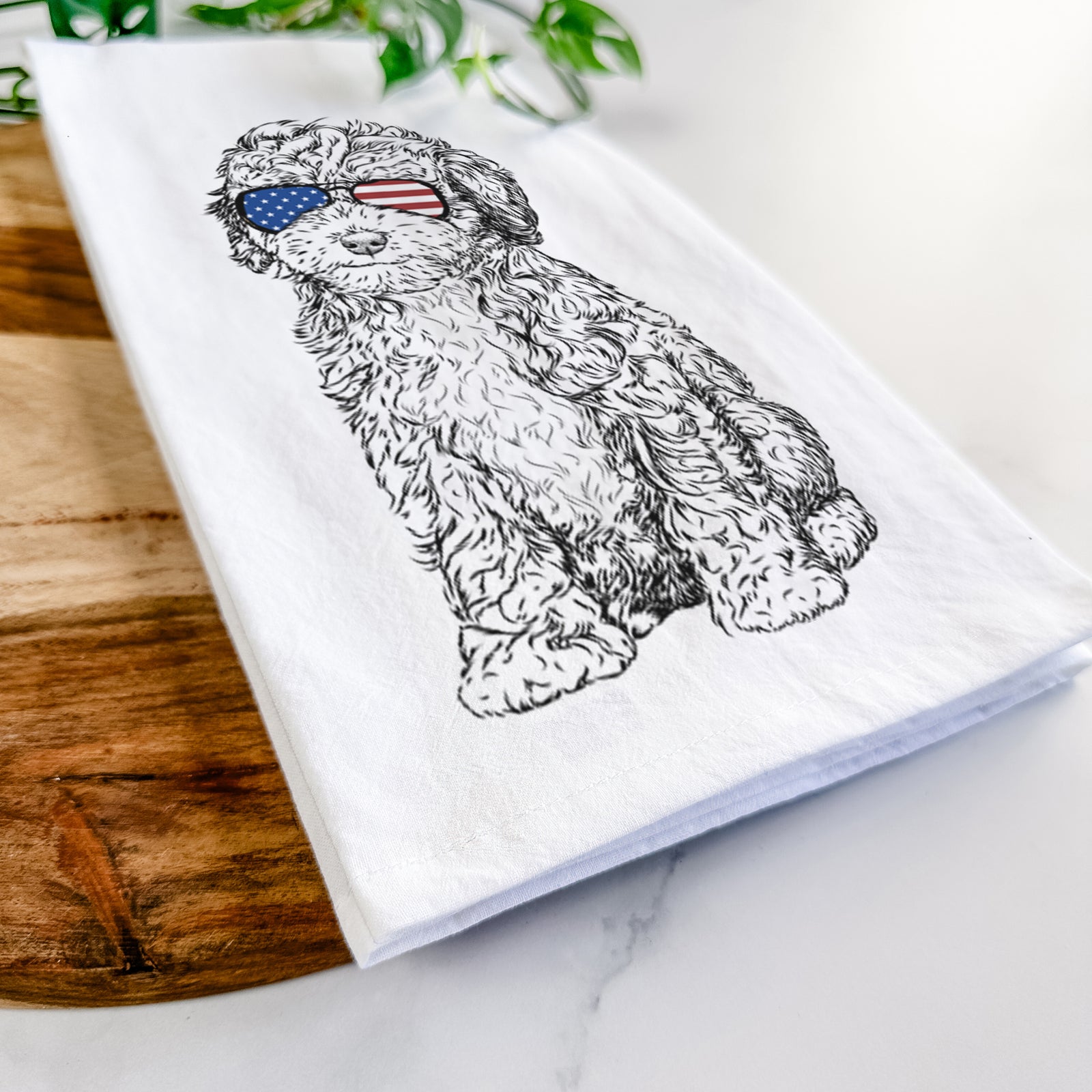 Hand-drawn sketch of Sweet Tea the Mini Doodle wearing American flag sunglasses on a tea towel