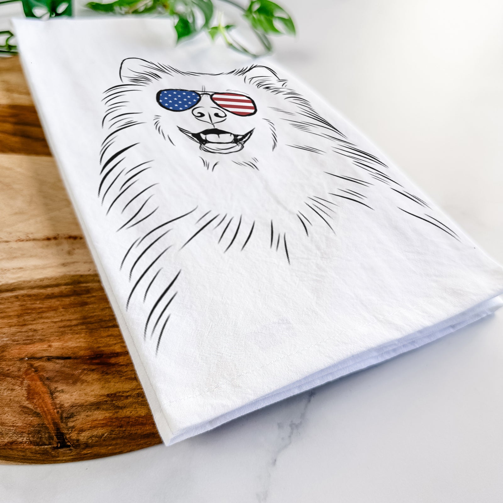 Hand-drawn sketch of Tillie the Samoyed wearing American flag sunglasses on a tea towel