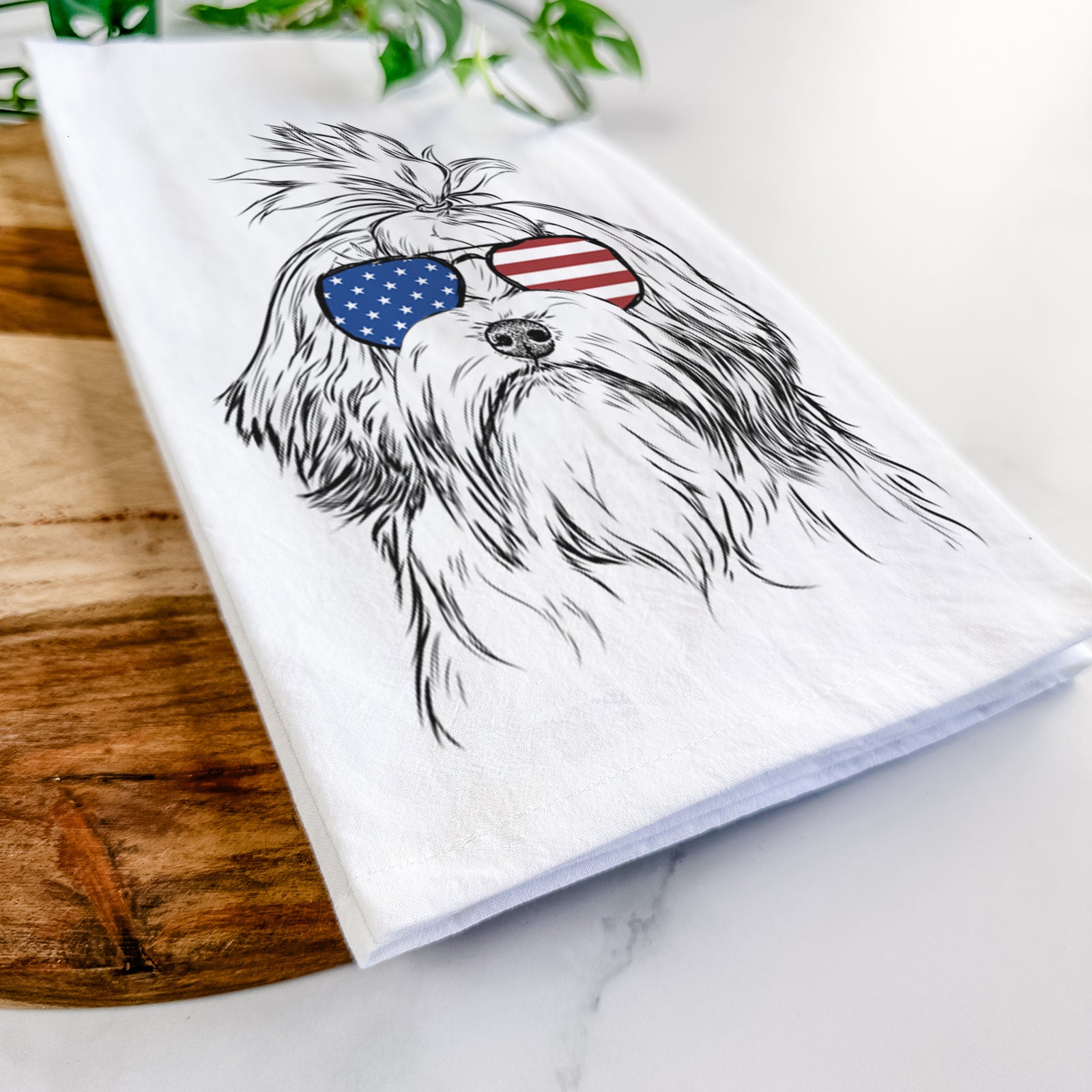Hand-drawn sketch of Tootsie the Lowchen wearing American flag sunglasses on a tea towel