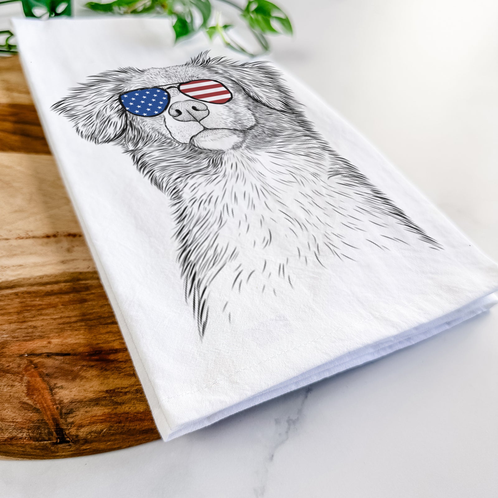 Hand-drawn sketch of Vixen the Nova Scotia Duck Tolling Retriever wearing American flag sunglasses on a tea towel