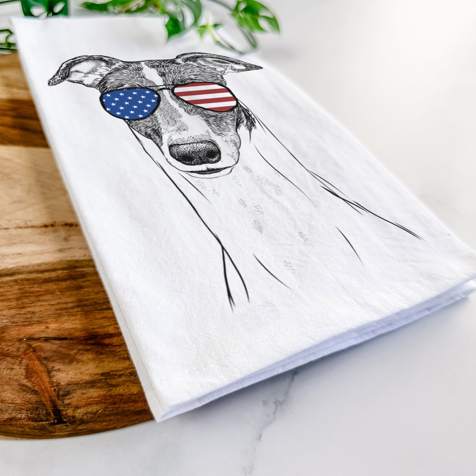Hand-drawn sketch of Vyncent the Greyhound wearing American flag sunglasses on a tea towel