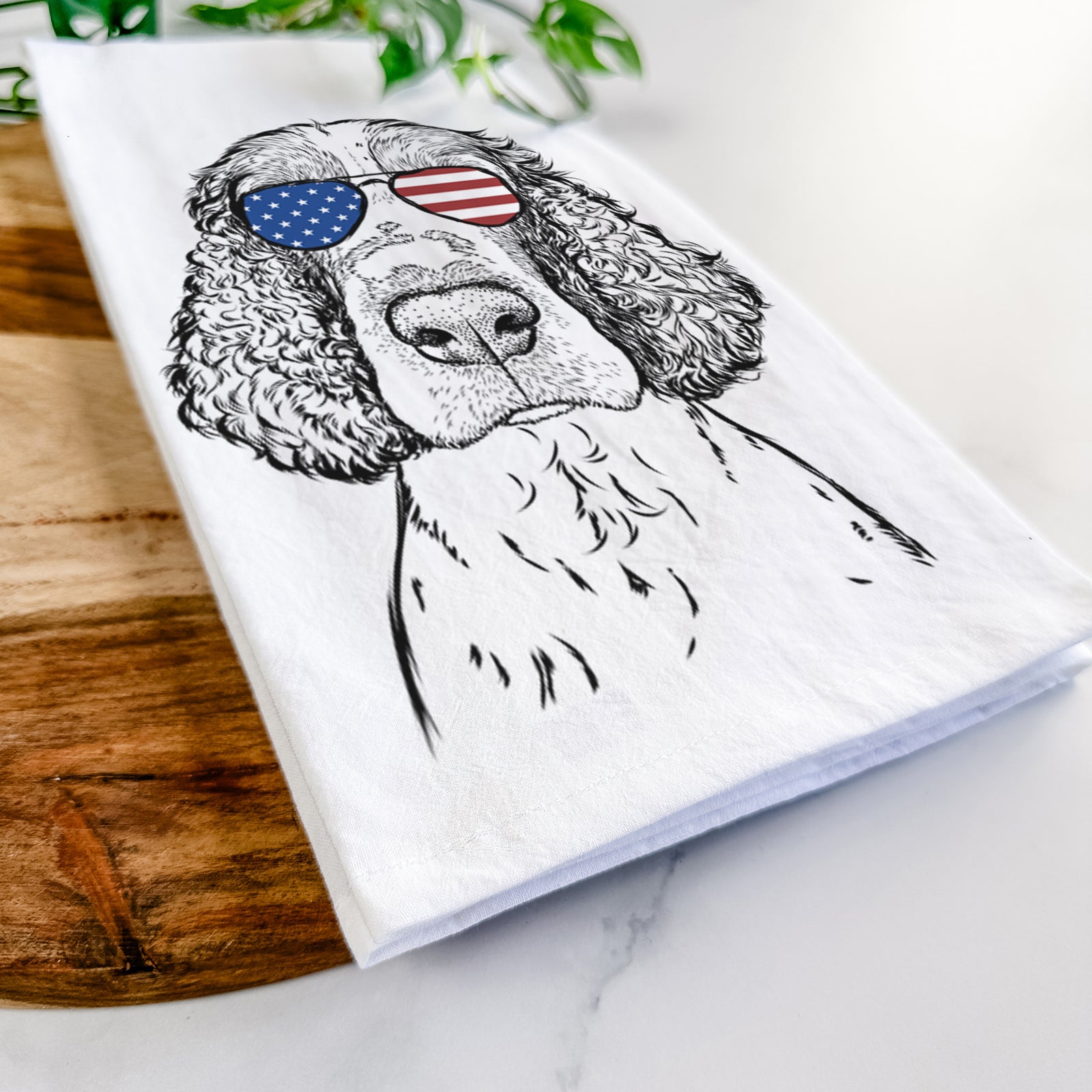 Hand-drawn sketch of Wilbur the English Springer Spaniel wearing American flag sunglasses on a tea towel