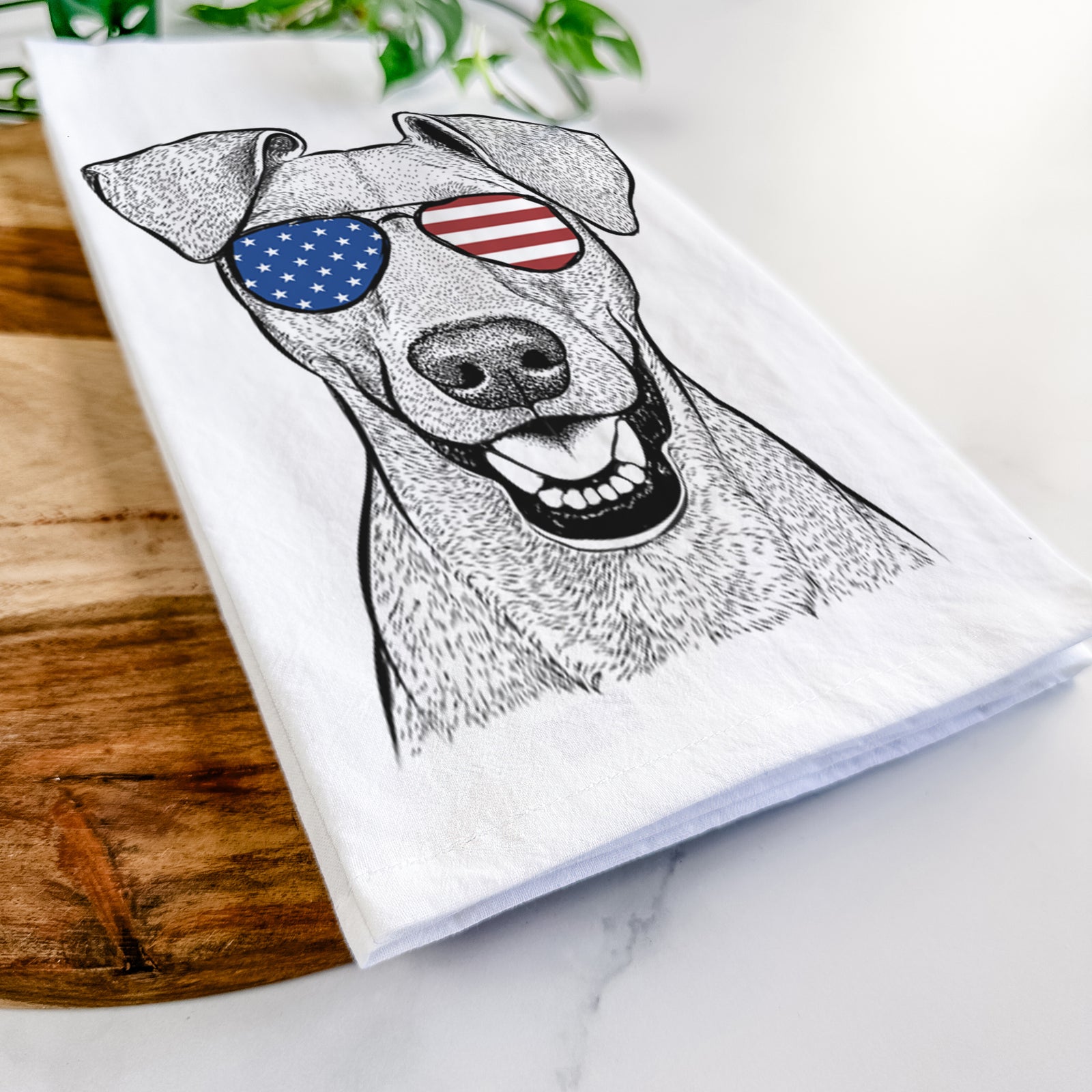Hand-drawn sketch of Willow the German Pinscher wearing American flag sunglasses on a tea towel