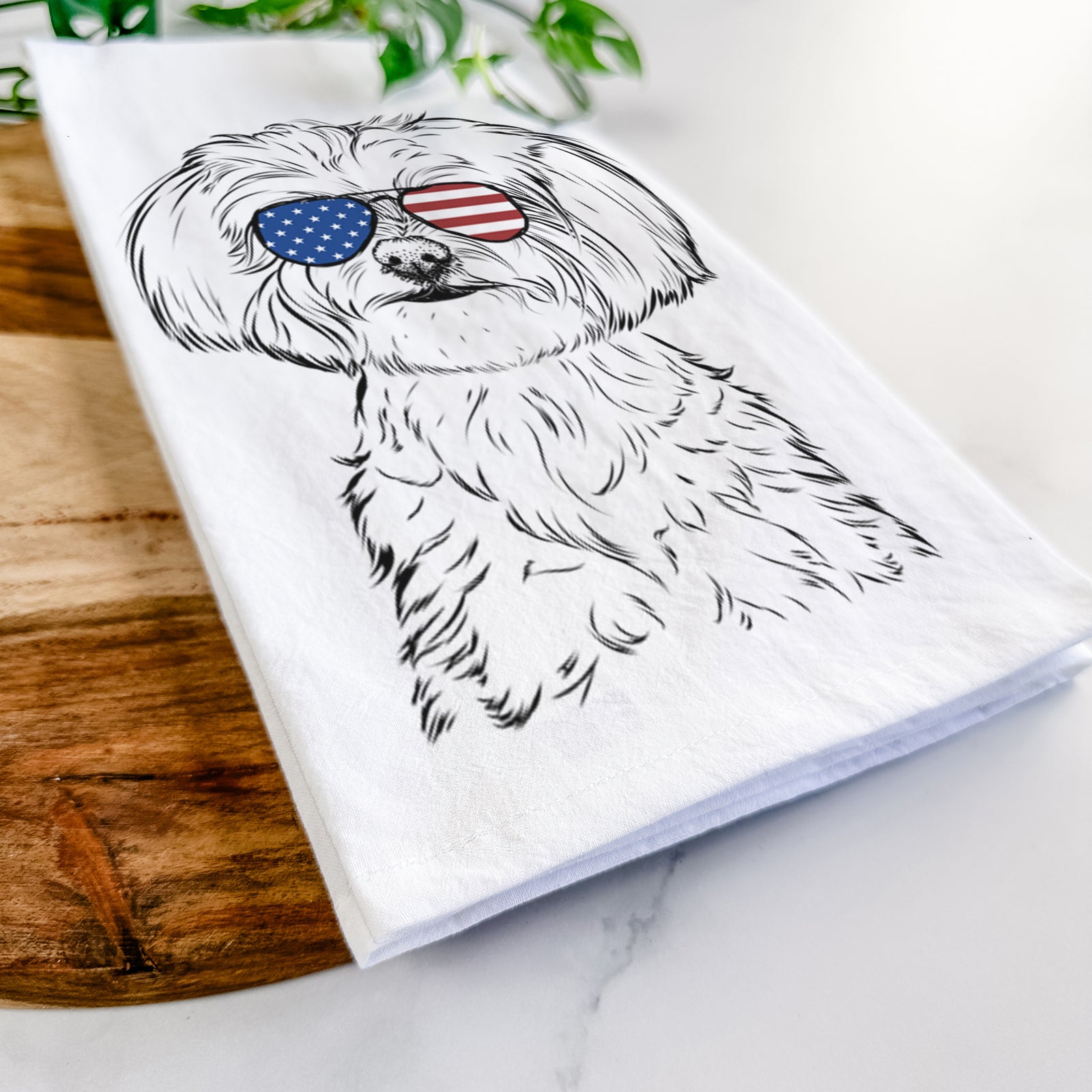 Hand-drawn sketch of Willow the Maltese wearing American flag sunglasses on a tea towel