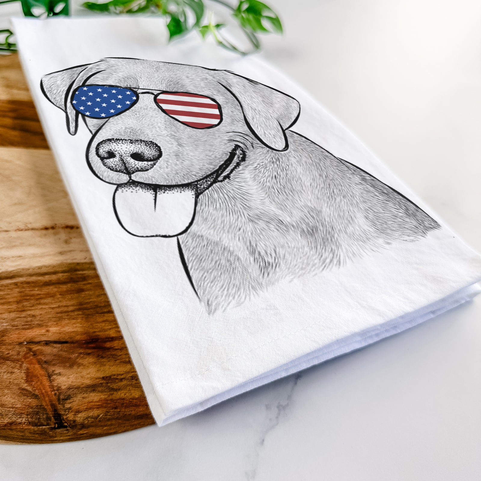 Hand-drawn sketch of Zeppelin the Black Labrador wearing American flag sunglasses on a tea towel