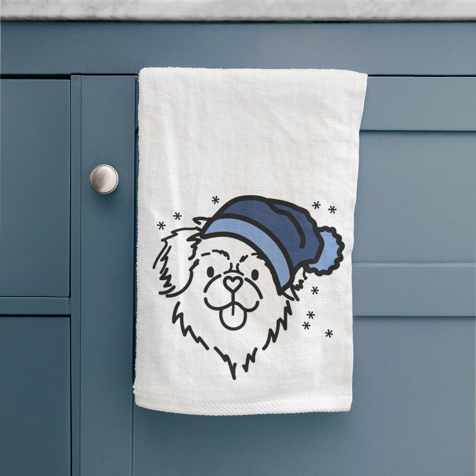 Minimalist line drawing of Jiji the Tibetan Spaniel wearing a winter beanie on a decorative hand towel