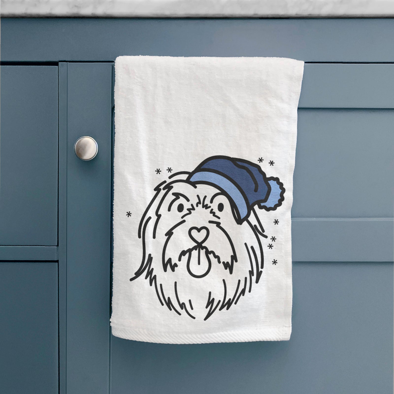 Minimalist line drawing of Tucker the Bearded Collie wearing a winter beanie on a decorative hand towel