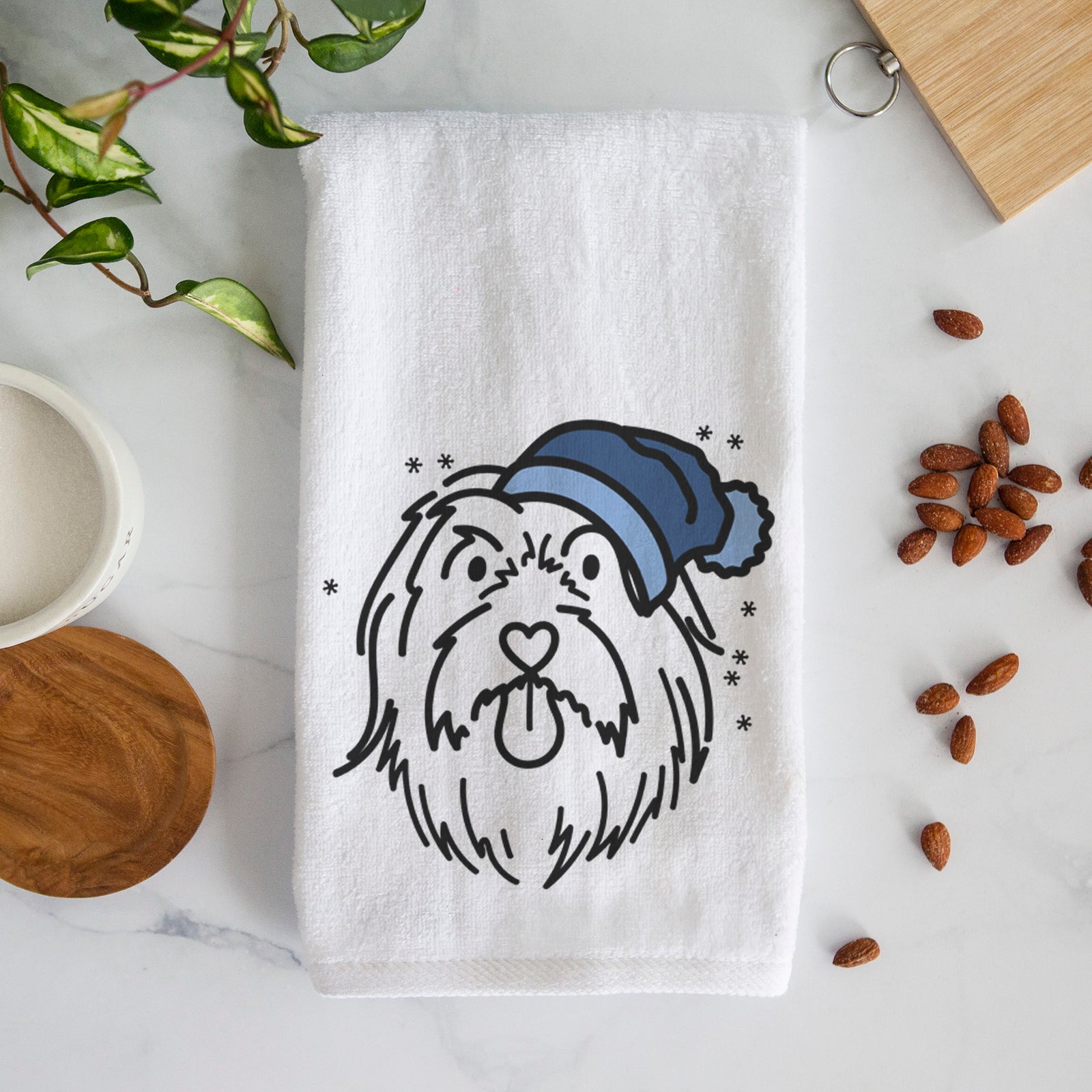 Minimalist line drawing of Tucker the Bearded Collie wearing a winter beanie on a decorative hand towel