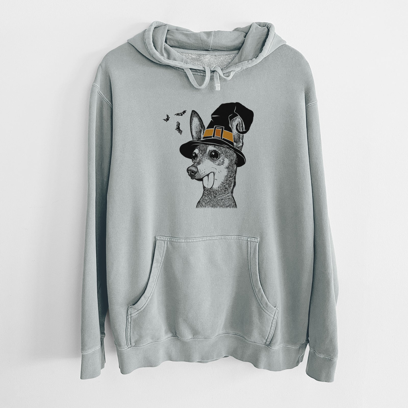 Hand-drawn sketch of Aaron the Chihuahua wearing a witch hat on a Sage Unisex pigment dyed hoodie