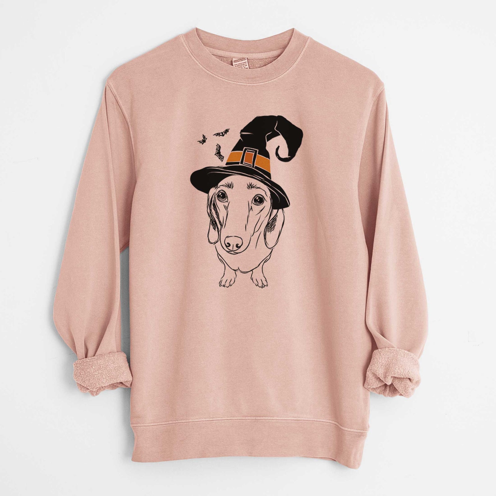 Hand-drawn sketch of Annabelle the Dachshund wearing a witch hat on a Dusty Pink Unisex pigment dyed crew sweatshirt