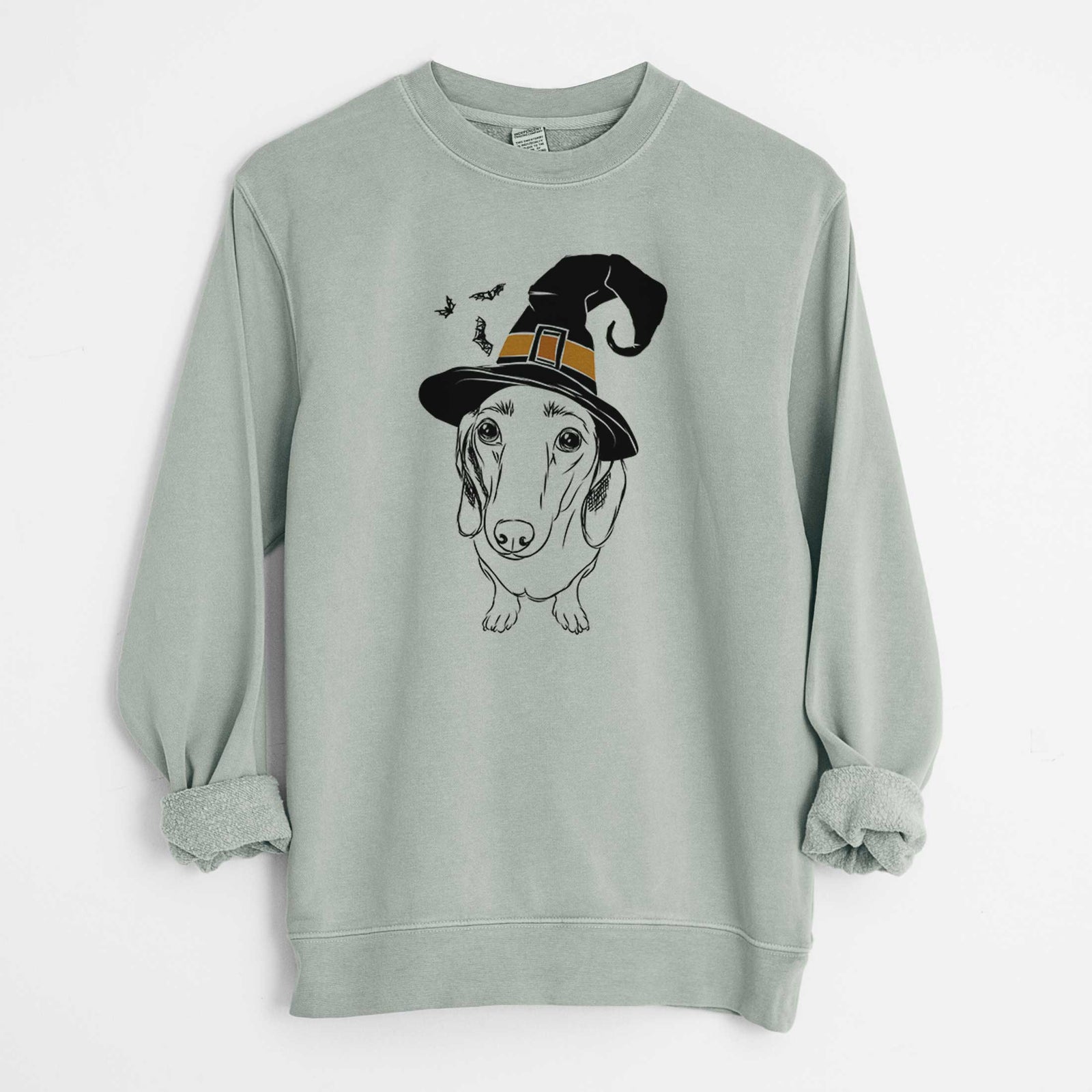 Hand-drawn sketch of Annabelle the Dachshund wearing a witch hat on a Sage Unisex pigment dyed crew sweatshirt