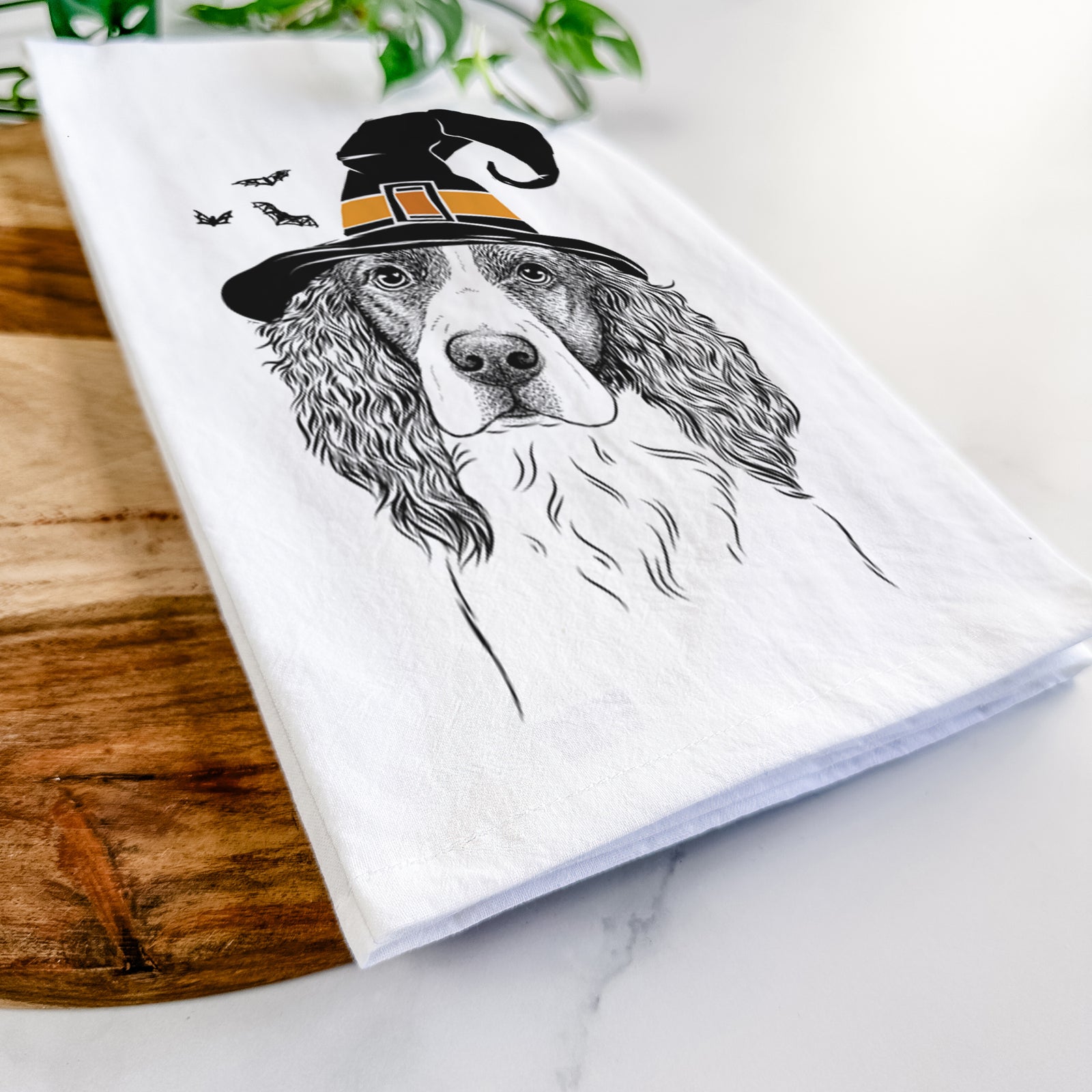 Hand-drawn sketch of Annie the English Springer Spaniel wearing a witch hat on a tea towel