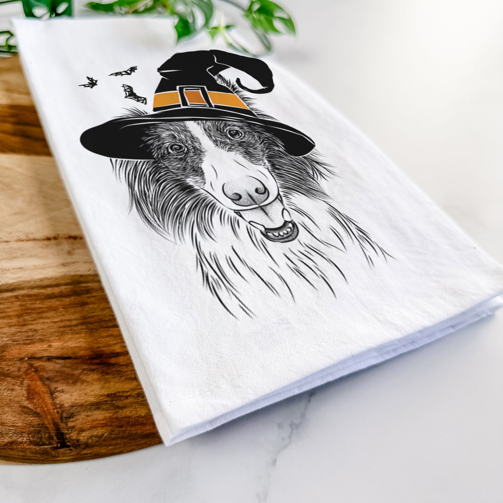 Hand-drawn sketch of Archie the Silken Windhound wearing a witch hat on a tea towel