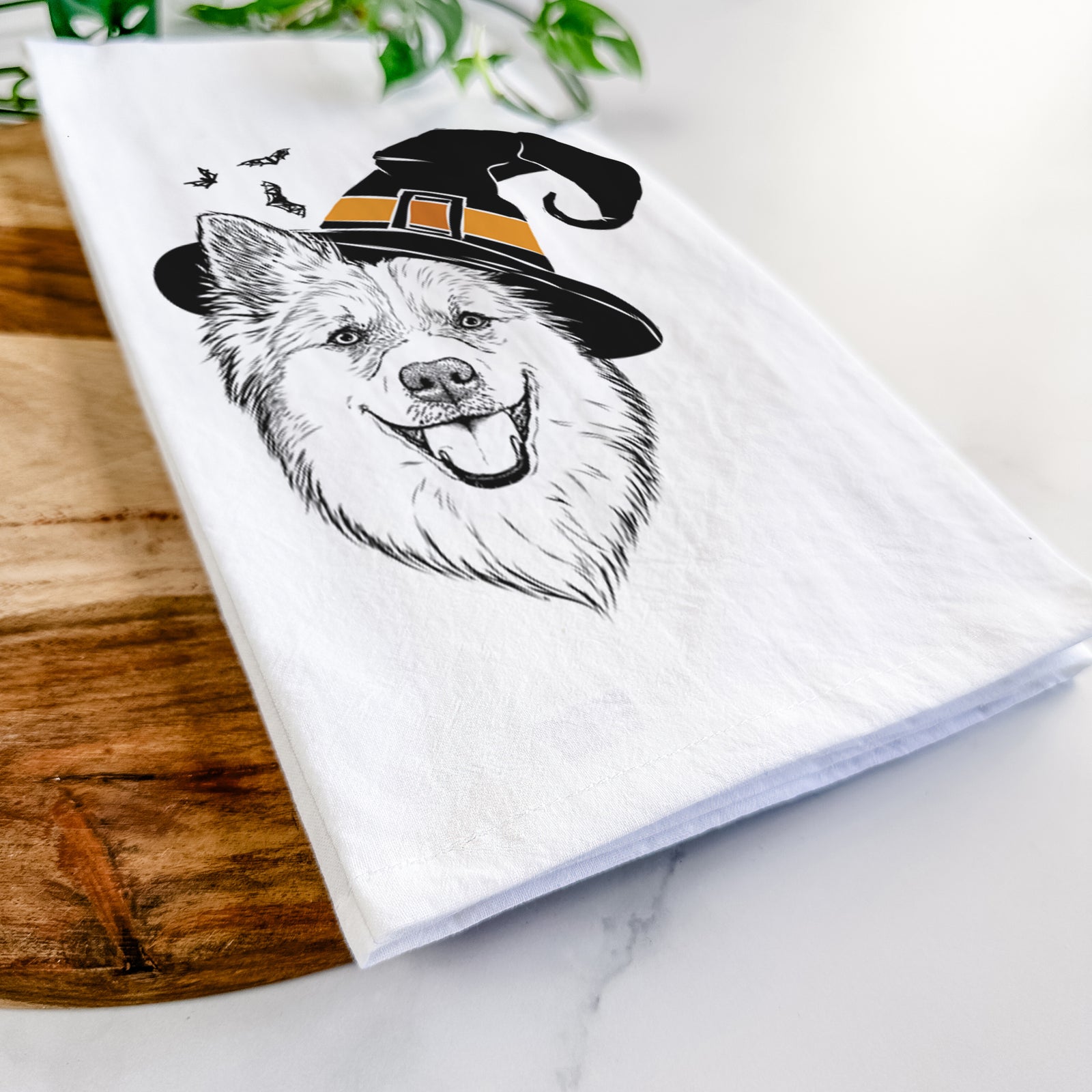 Hand-drawn sketch of Ari the Icelandic Sheepdog wearing a witch hat on a tea towel