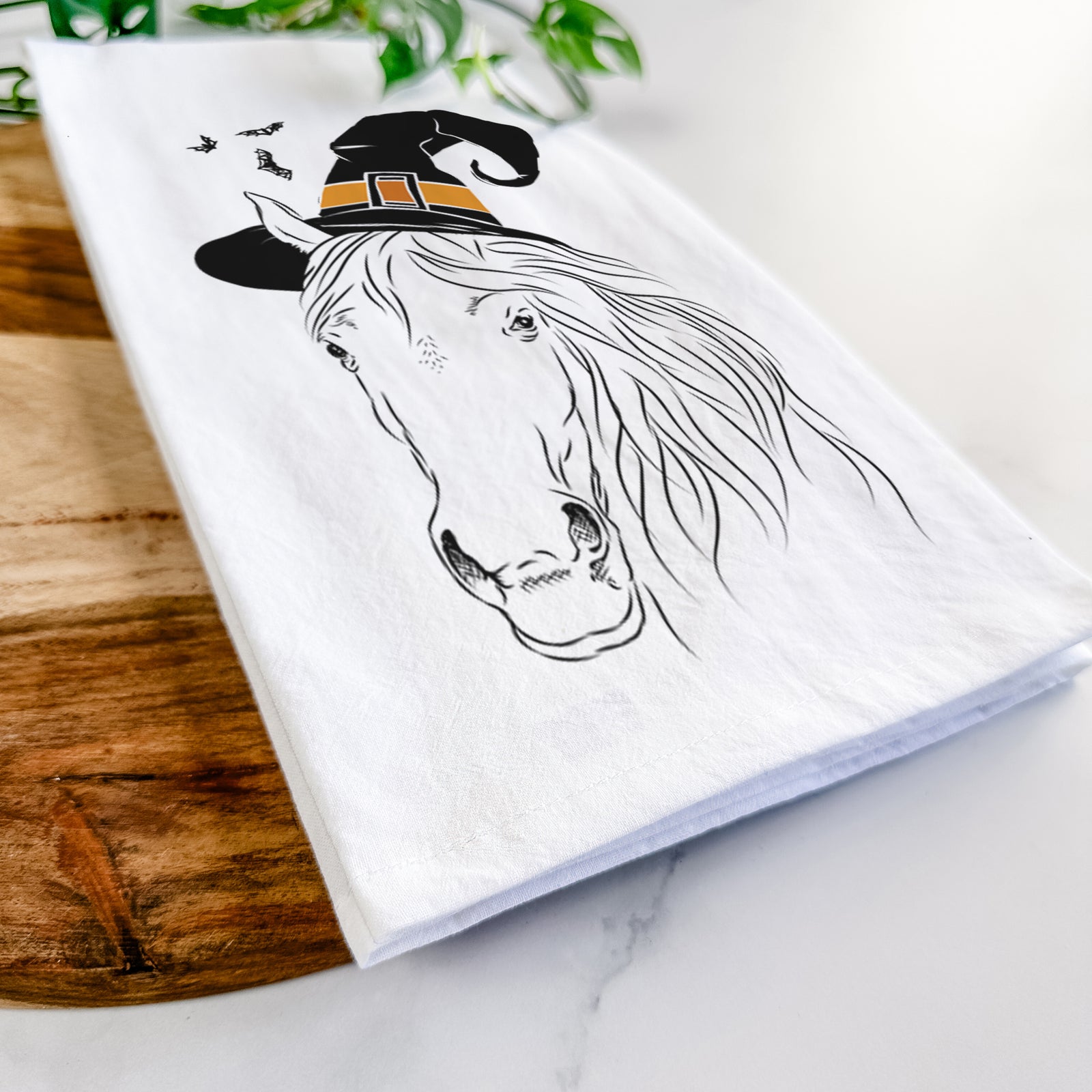 Hand-drawn sketch of Aria the Horse wearing a witch hat on a tea towel