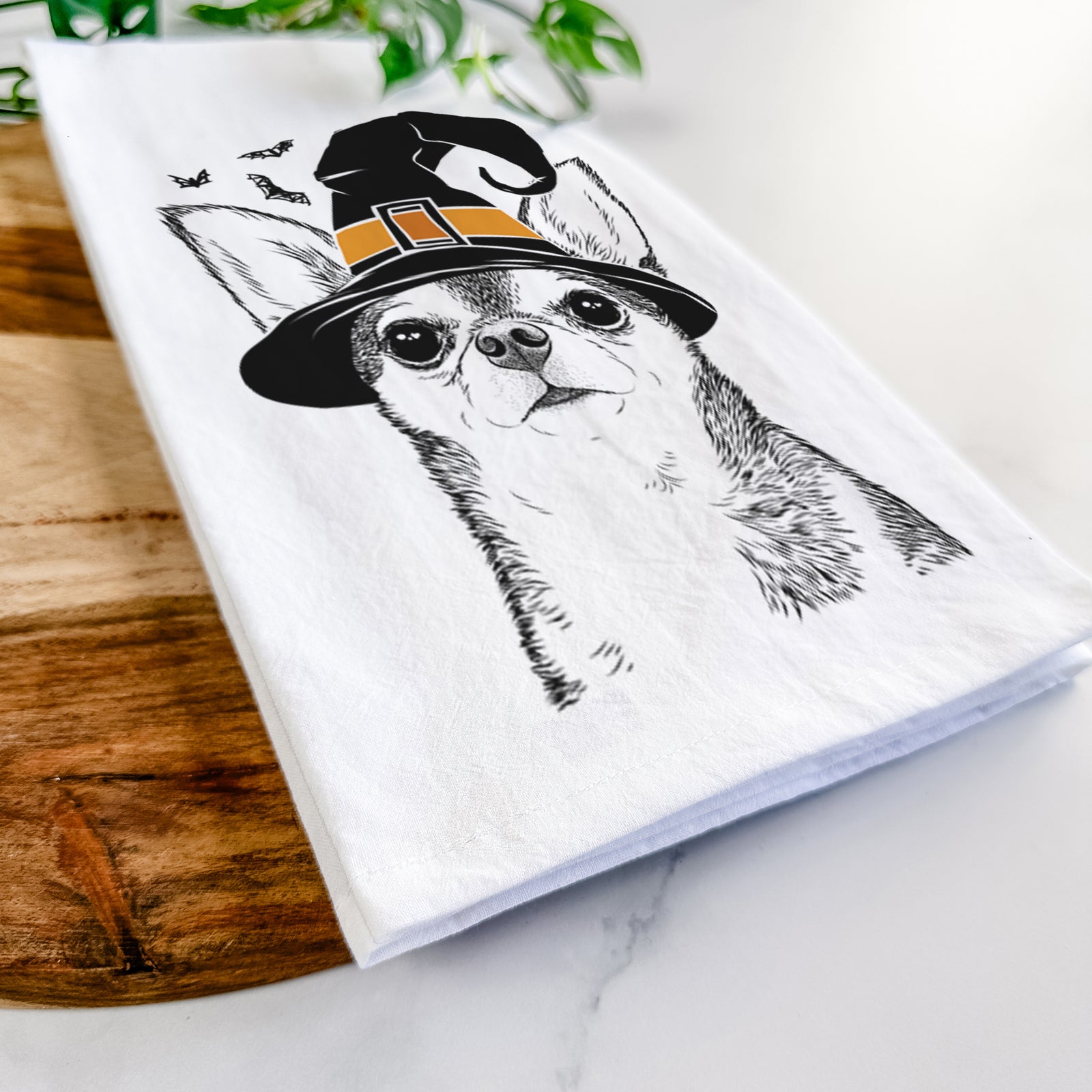 Hand-drawn sketch of Baby the Chihuahua wearing a witch hat on a tea towel