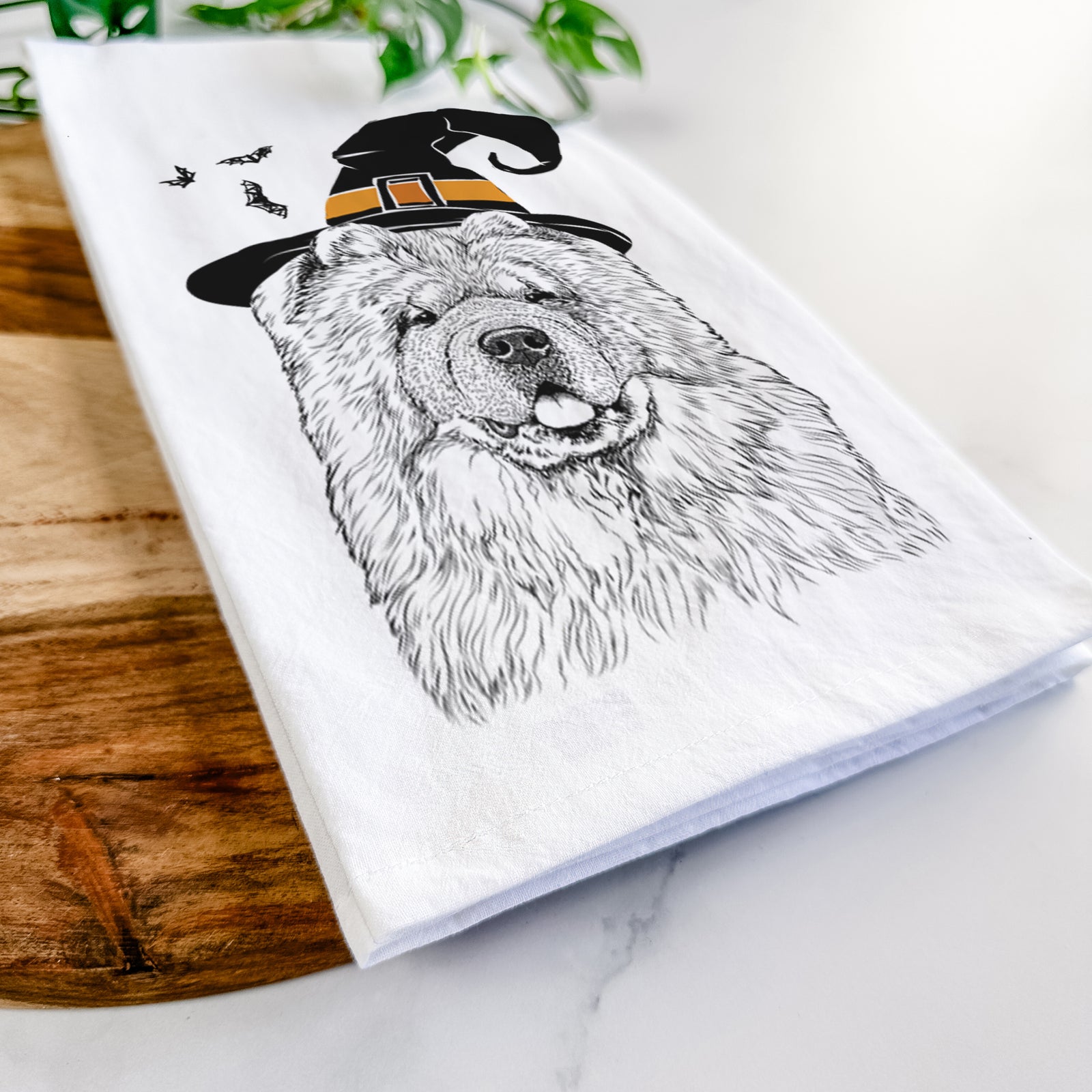Hand-drawn sketch of Baloo the Chow Chow wearing a witch hat on a tea towel