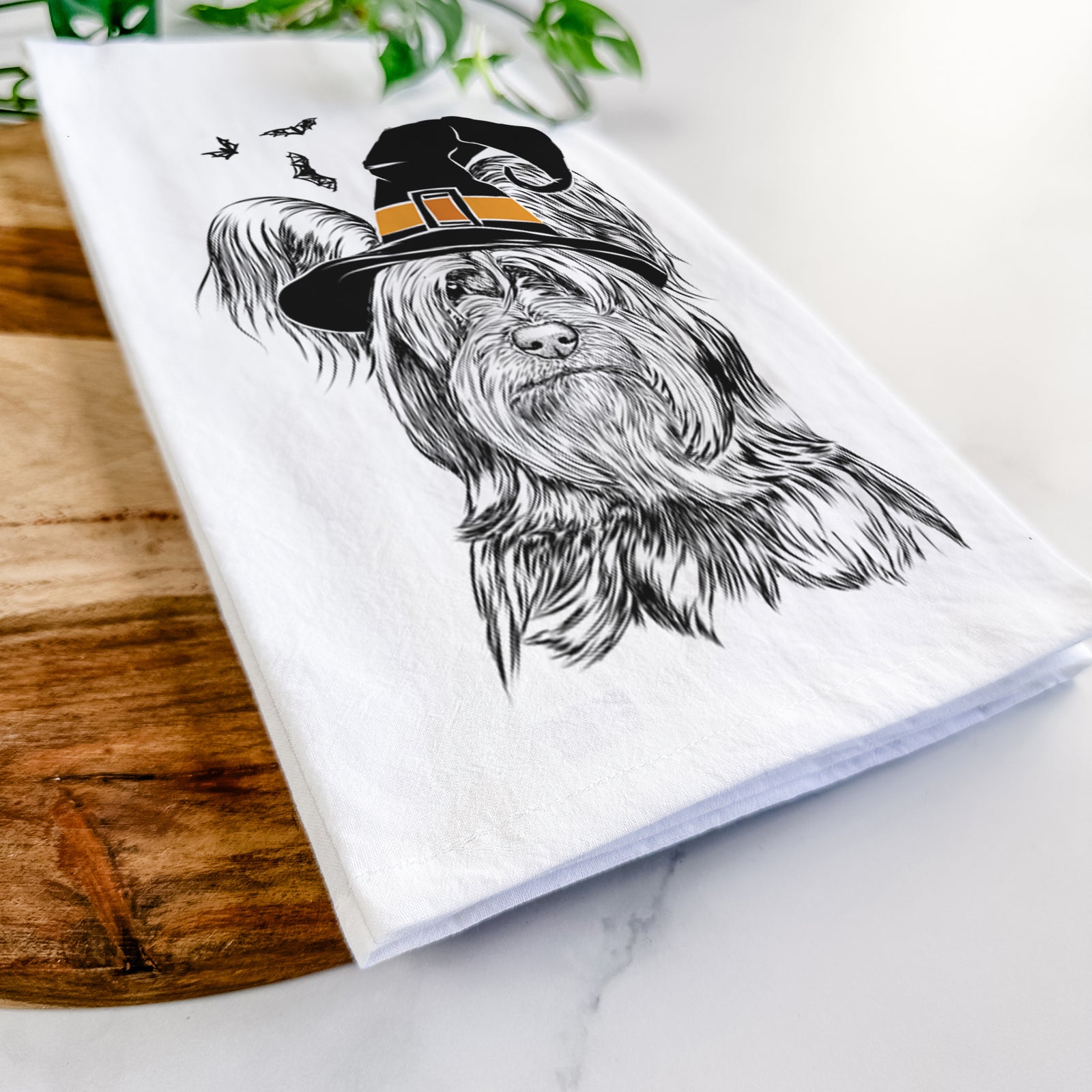 Hand-drawn sketch of Bandit the Skye Terrier wearing a witch hat on a tea towel