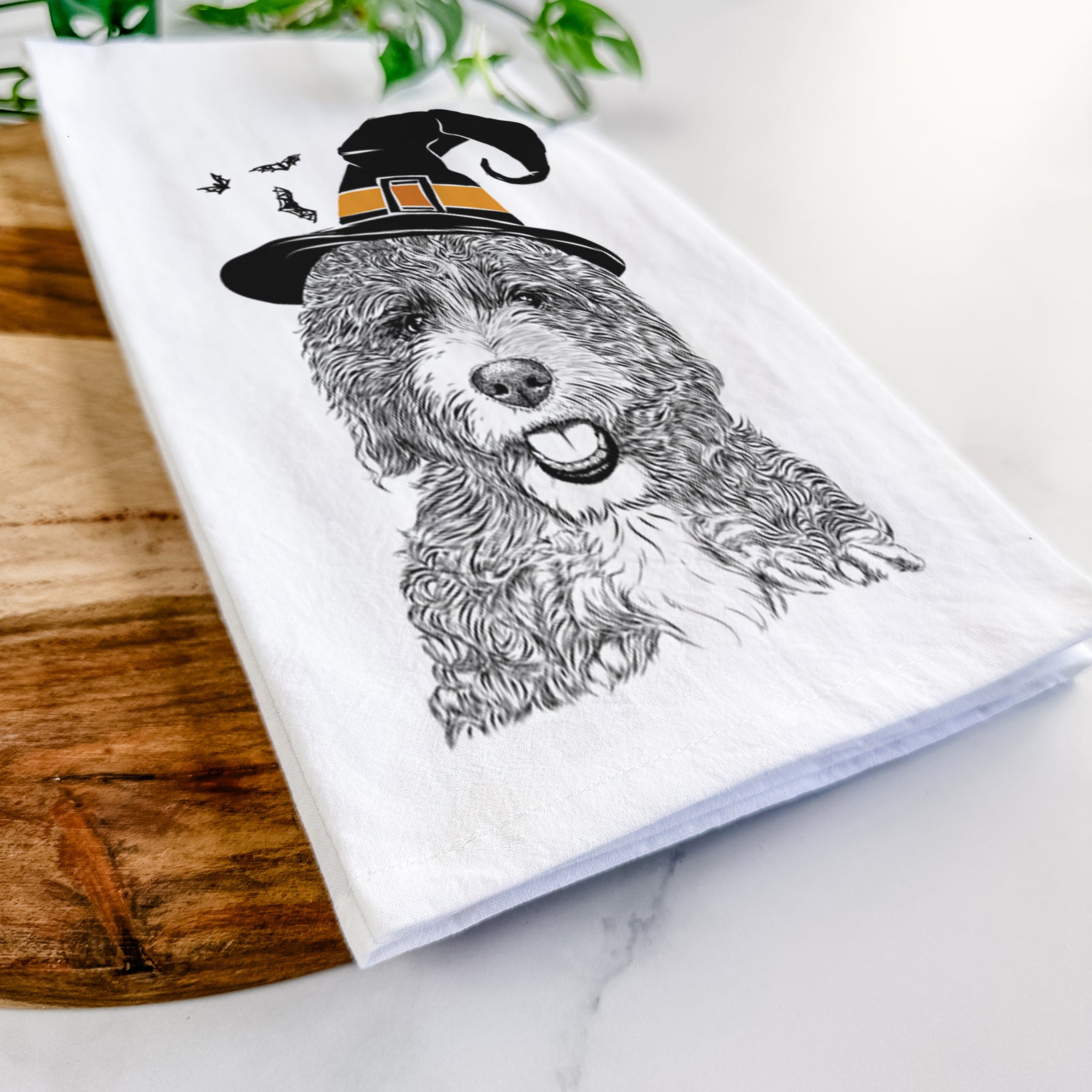 Hand-drawn sketch of Bash the Bernedoodle wearing a witch hat on a tea towel