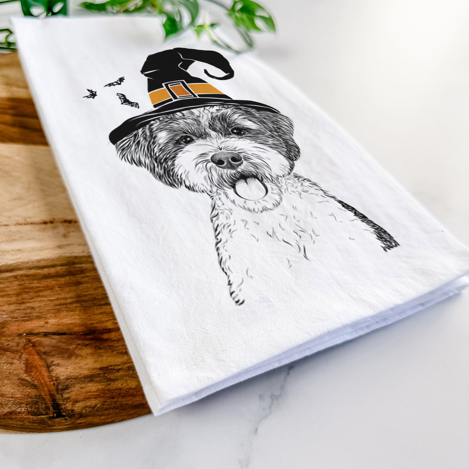 Hand-drawn sketch of Bella the Cockapoo wearing a witch hat on a tea towel